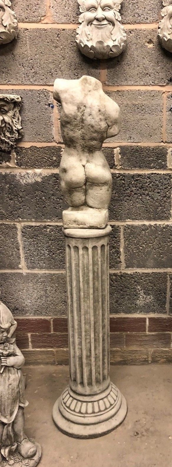 Back view of female torso statue on limestone plinth, highlighting realistic sculptural form. Classic garden ornament with weather-resistant finish.