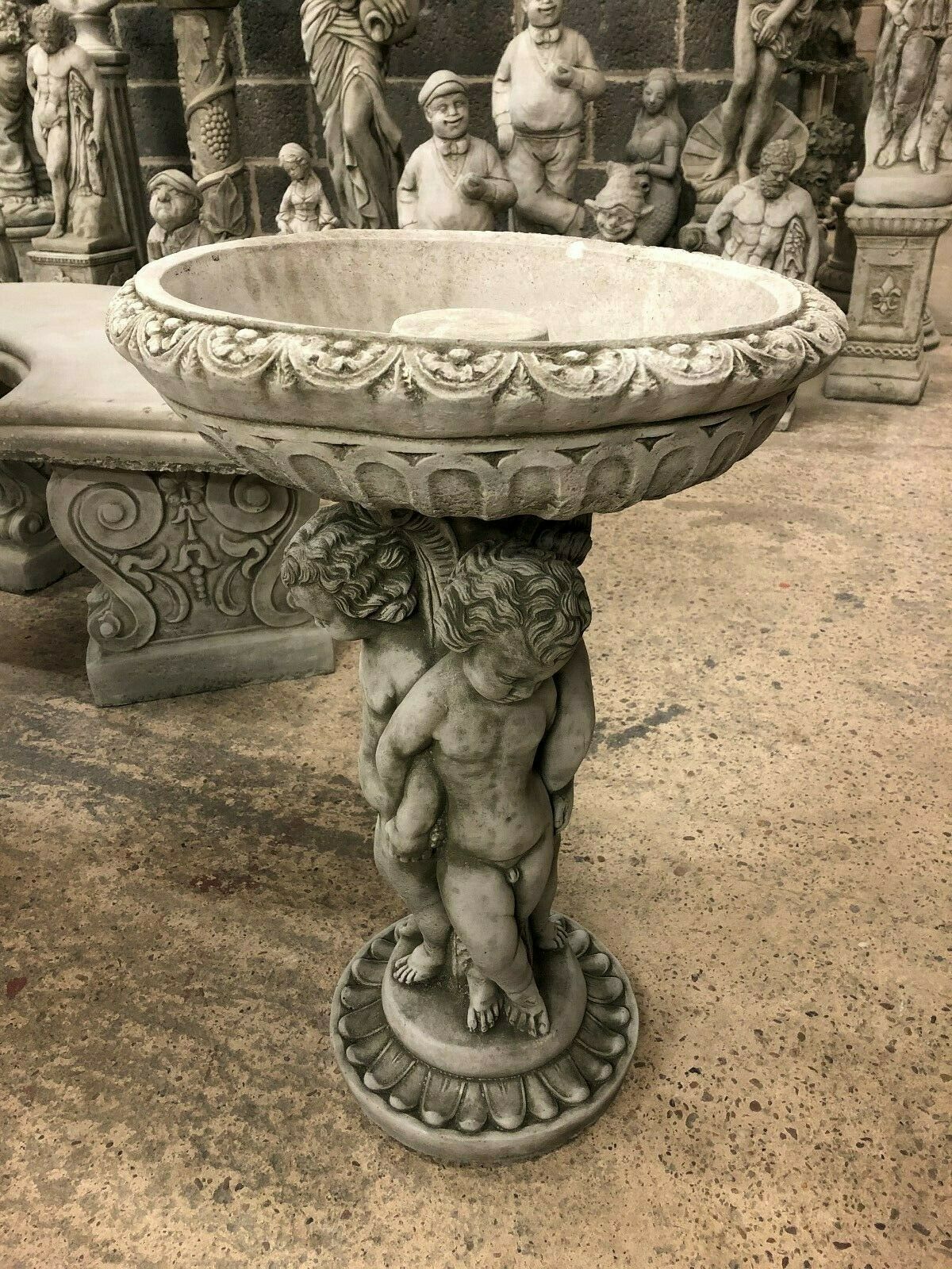 Cherub Garden Bird Bath - Stone Antique Finish with ornate basin and trio cherub pedestal. Ideal for outdoor garden décor and bird feeding.