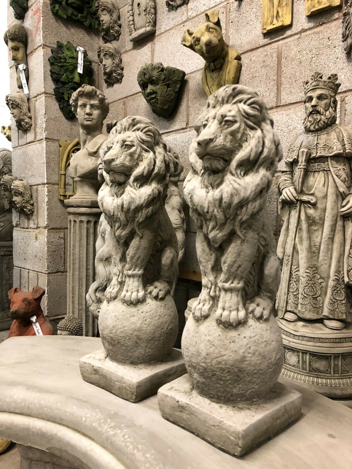 Pair of stone lion statues for garden decor, crafted from durable limestone with intricate detailing, ideal for outdoor finial ornamentation.