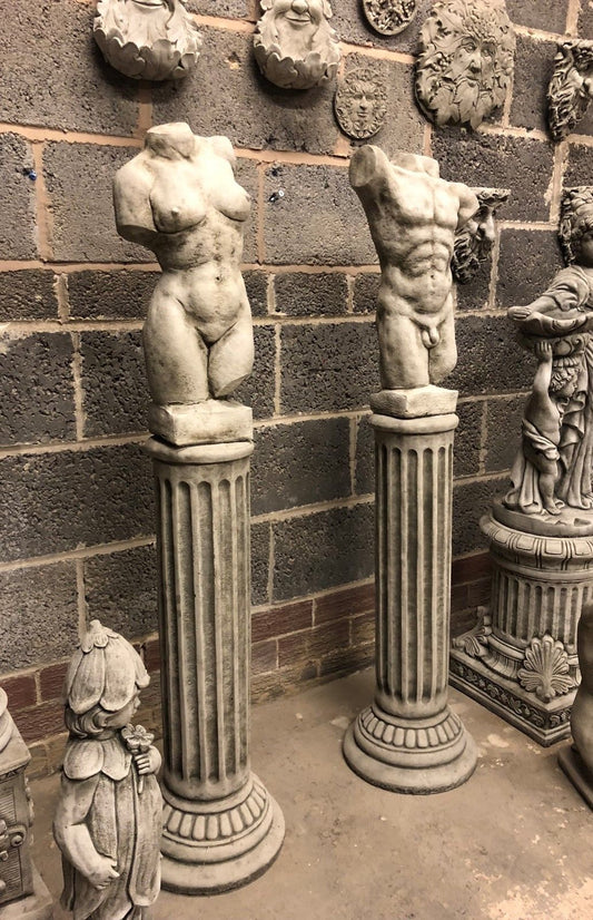 Stone garden torso statues on Grecian plinths, featuring male and female nude forms in antique grey finish. Ideal for outdoor weather-resistant decor.