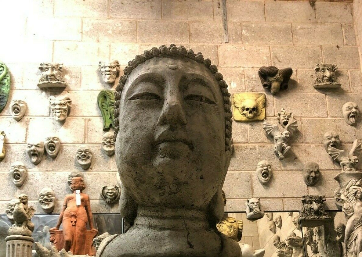 Front close-up of large stone Buddha head statue with calm facial features. Ideal for garden decor or spiritual outdoor spaces.