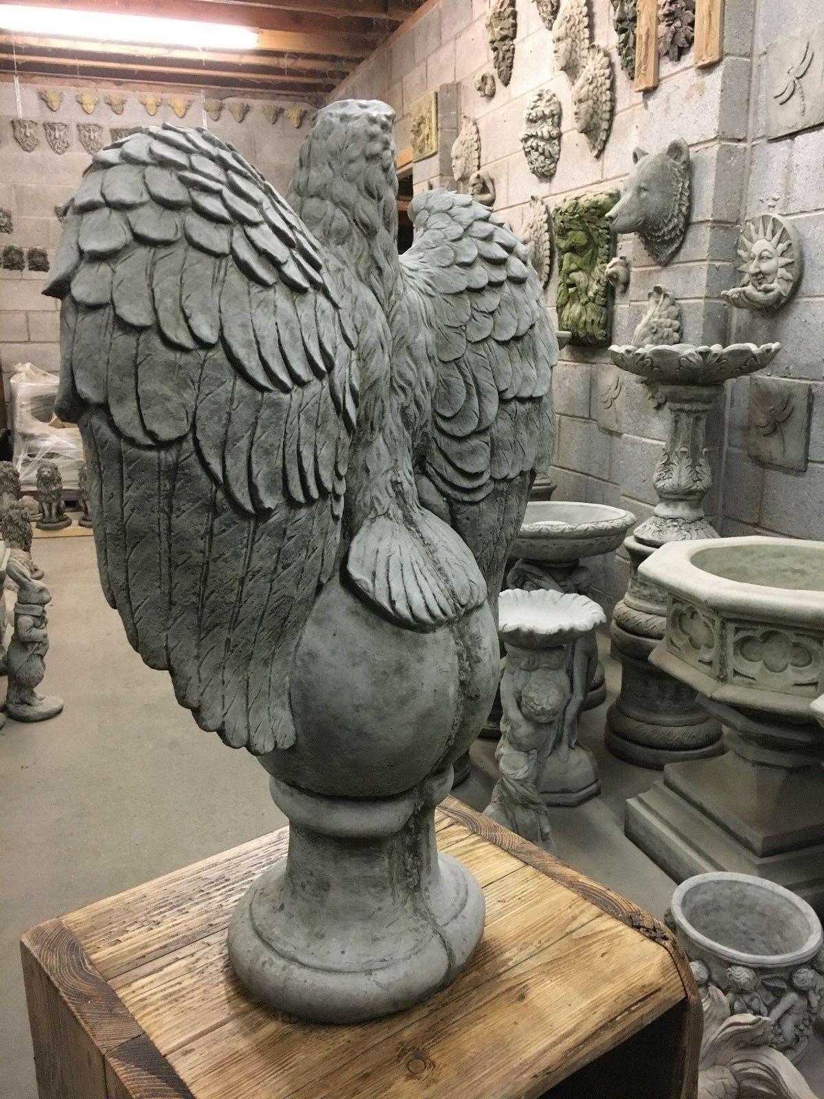 Rear view of large stone eagle statue showing intricate wing detailing, crafted for outdoor garden decoration and durability.