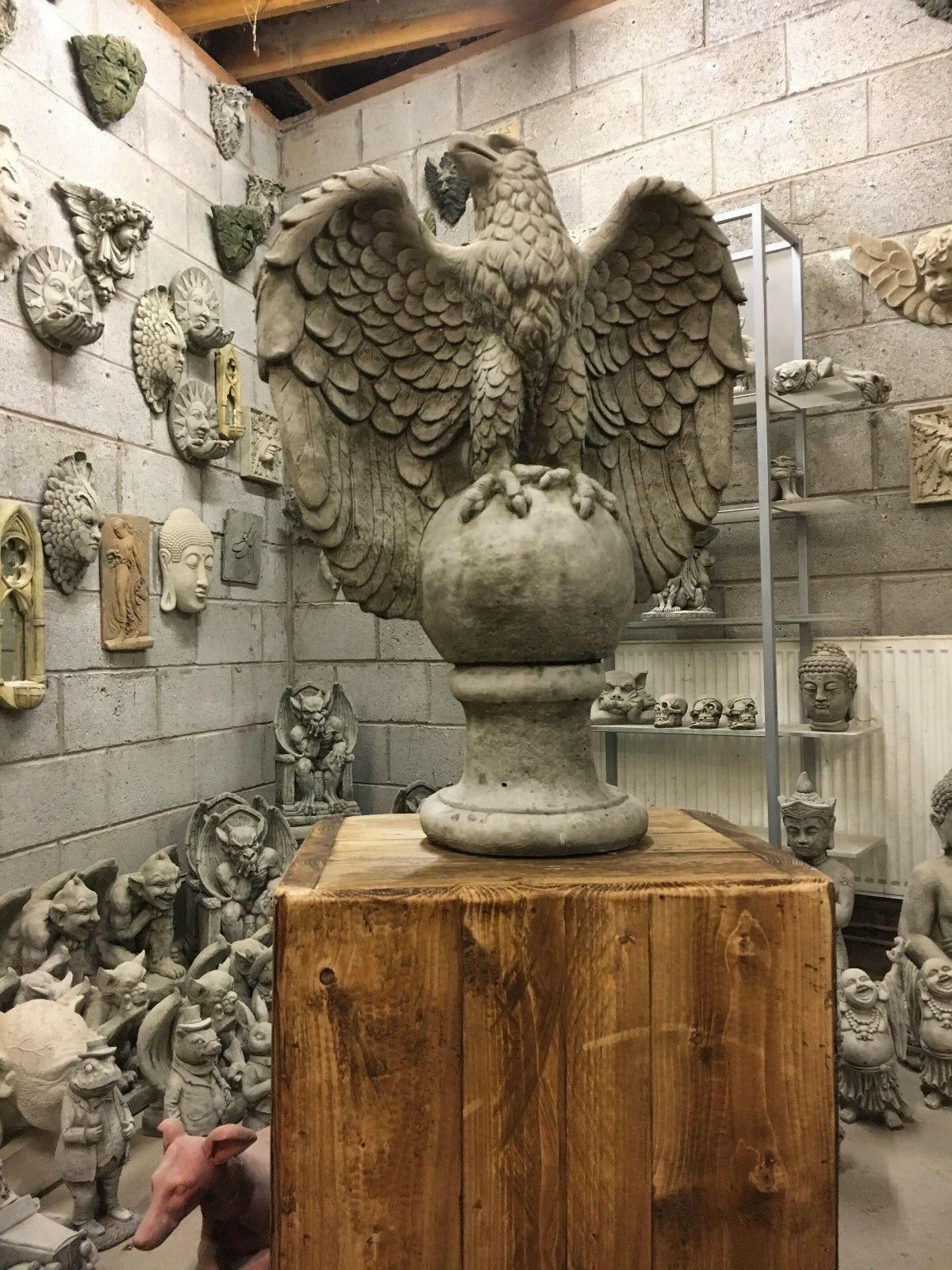 Classic outdoor garden decor featuring a large stone eagle statue on a globe base, ideal for home and lawn ornamentation.