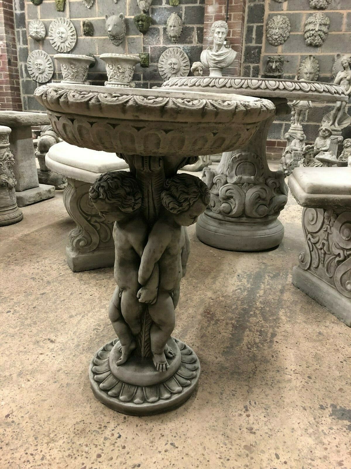 Side view of Cherub Garden Bird Bath - Stone Antique Finish with intricate cherub sculpture and floral basin edge. Timeless garden centerpiece.
