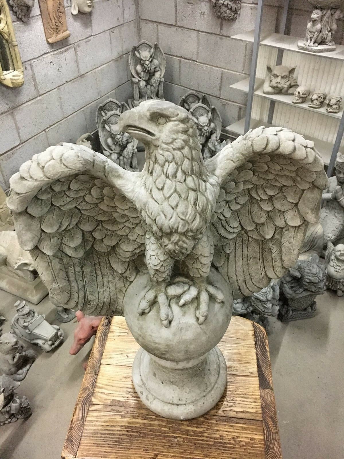 Top view of large limestone eagle statue with spread wings, designed as a striking centerpiece for garden or patio settings.