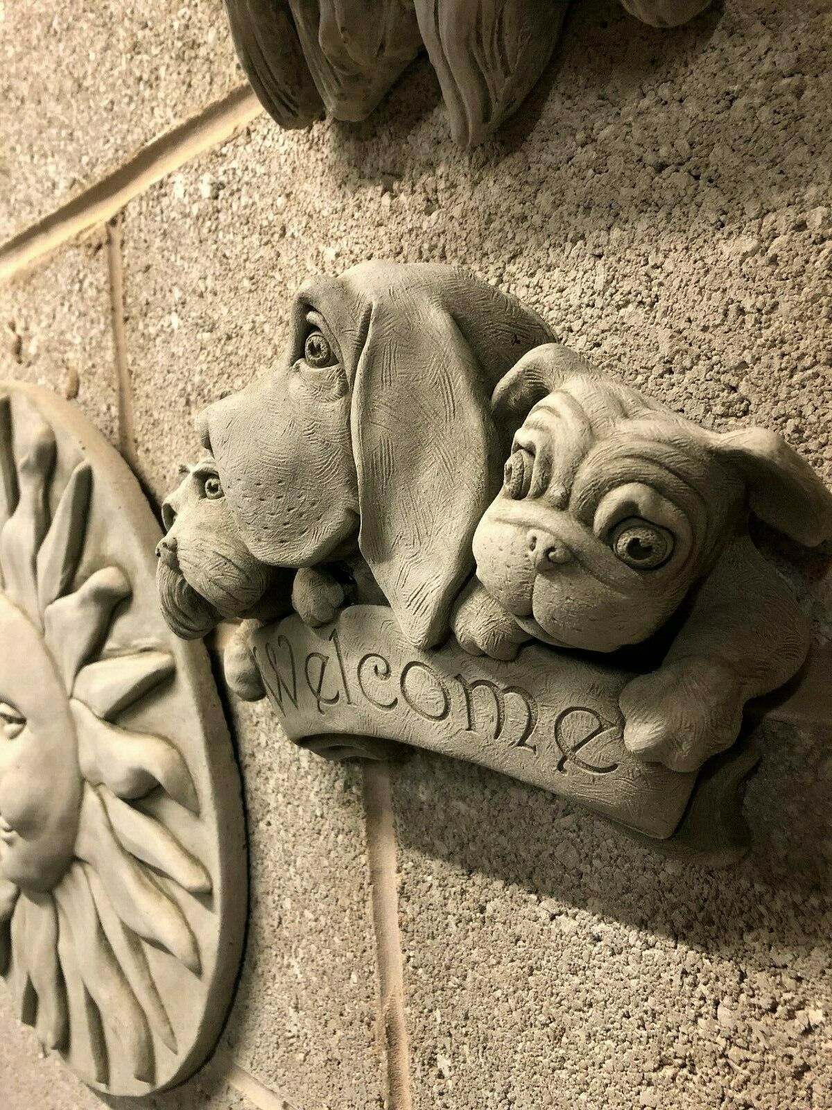 Side view of weatherproof Welcome Dog Garden Plaque showing intricate stone carving and durable build for home or patio decoration.