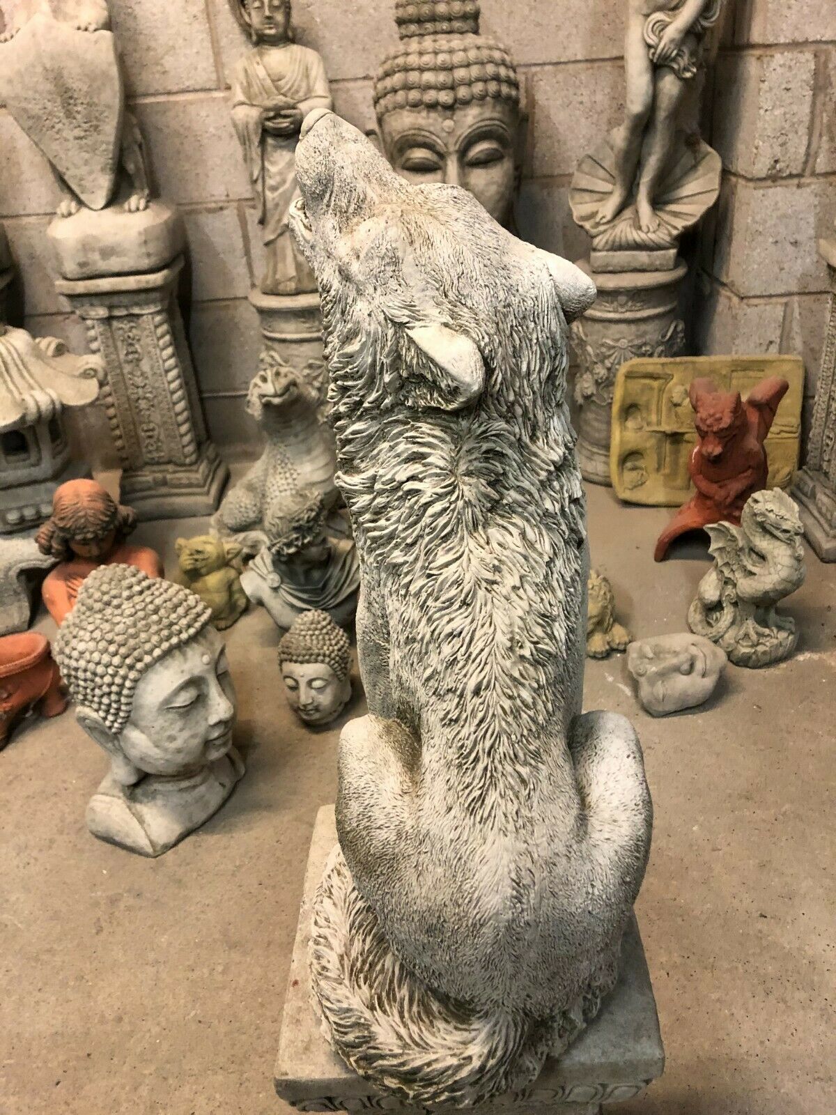 Overhead rear view of Howling Wolf Garden Statue with antique stone finish, seated on a decorative pedestal for outdoor use.