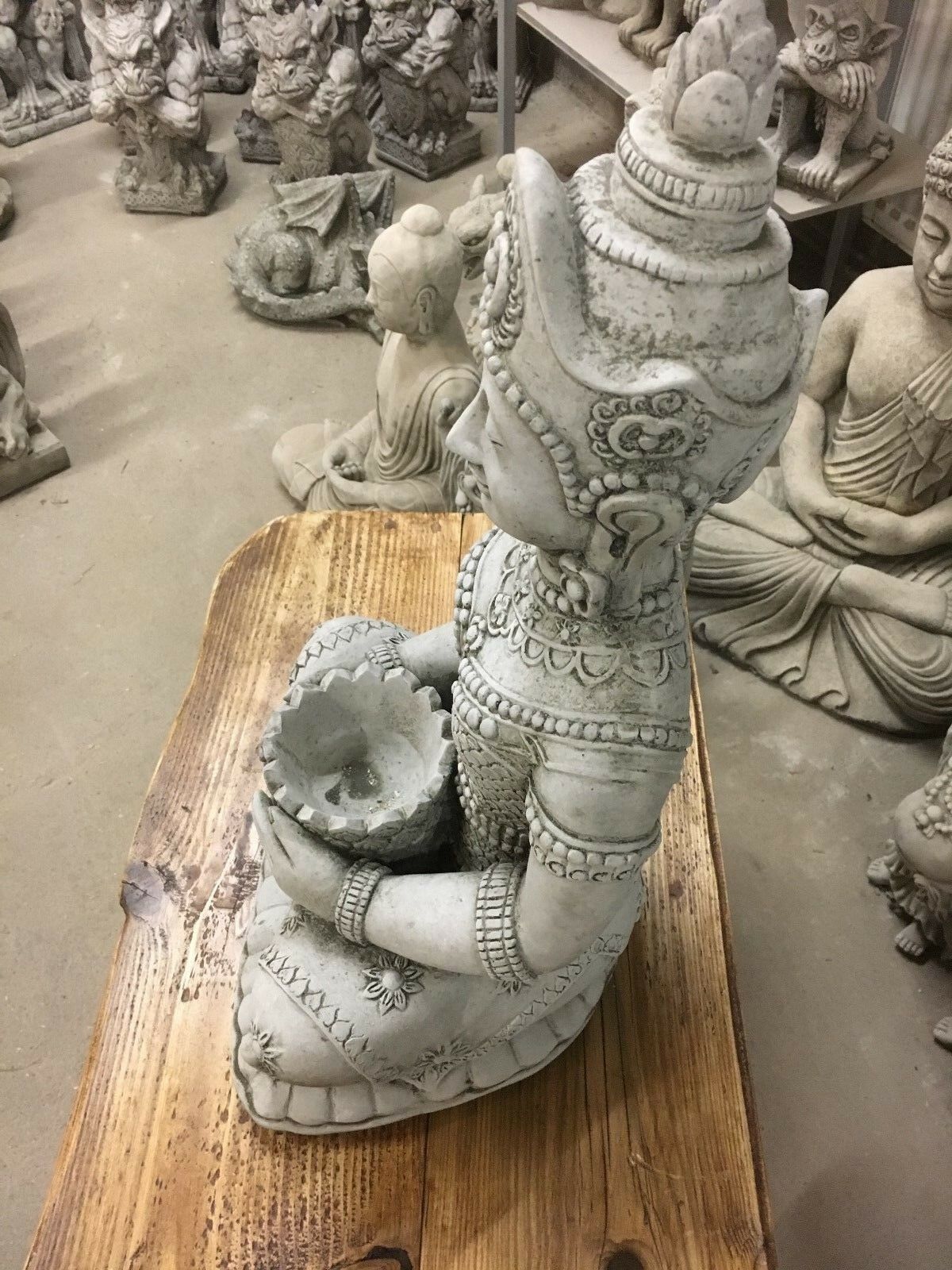 Side view of intricately carved Peaceful Stone Buddha Statue holding a lotus bowl, perfect for enhancing garden serenity and spiritual ambiance.