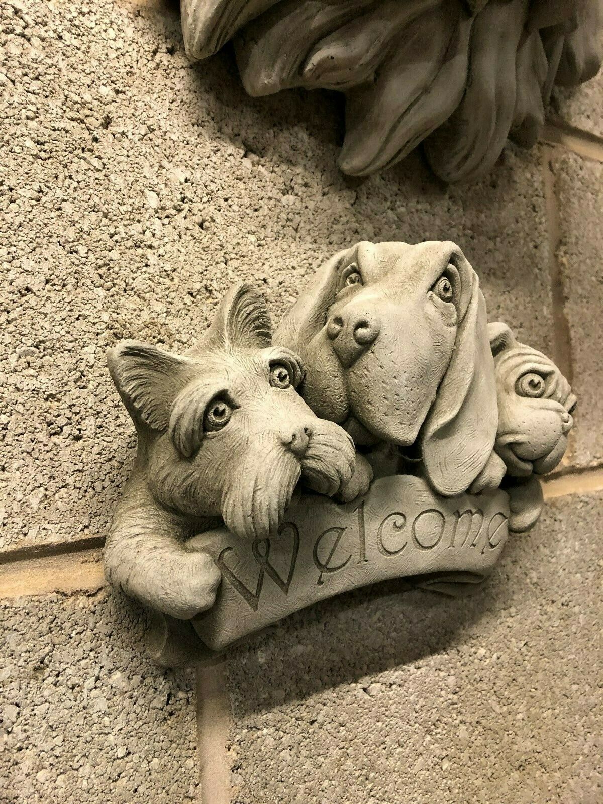 Close-up of Stone Welcome Dog Garden Plaque with lifelike dog expressions and engraved 'Welcome' text, perfect for garden or porch decor.