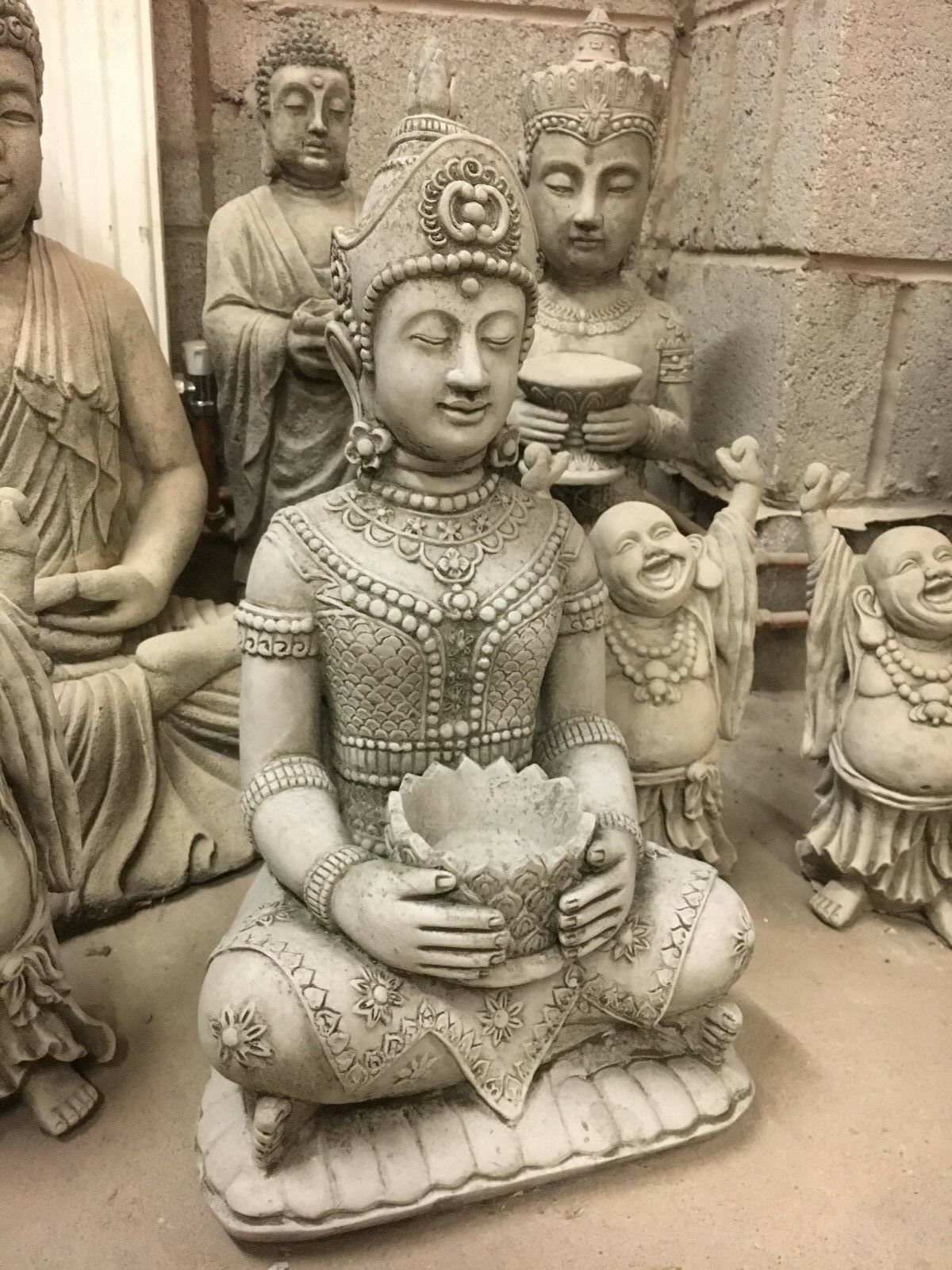 Decorative Stone Buddha Statue surrounded by other sculptures, showcasing antique finish and meditative posture for peaceful garden decor.