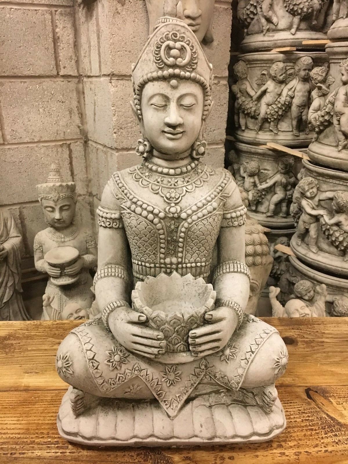 Close-up of serene Buddha face and lotus bowl in antique grey stone, ideal for spiritual garden ornamentation and peaceful ambiance.