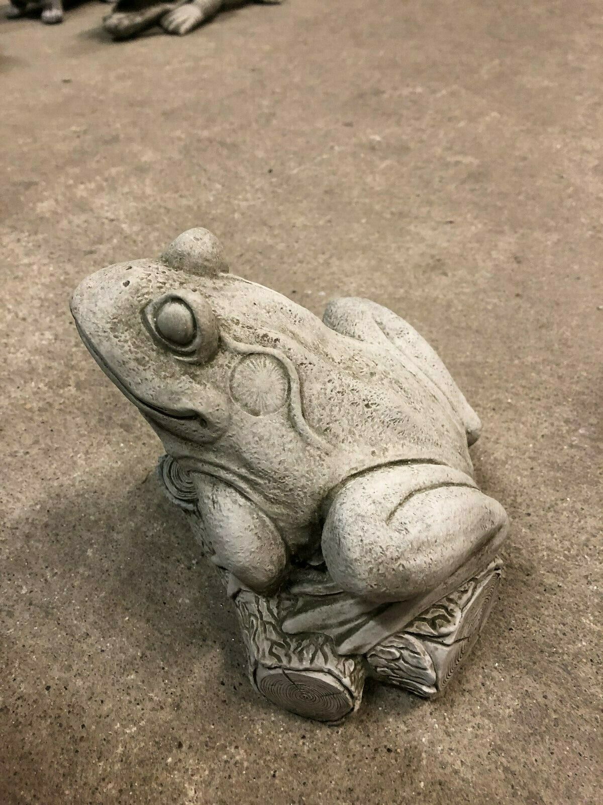 Top view of stone frog garden sculpture on log, showcasing detailed craftsmanship and weather-resistant design for outdoor use.
