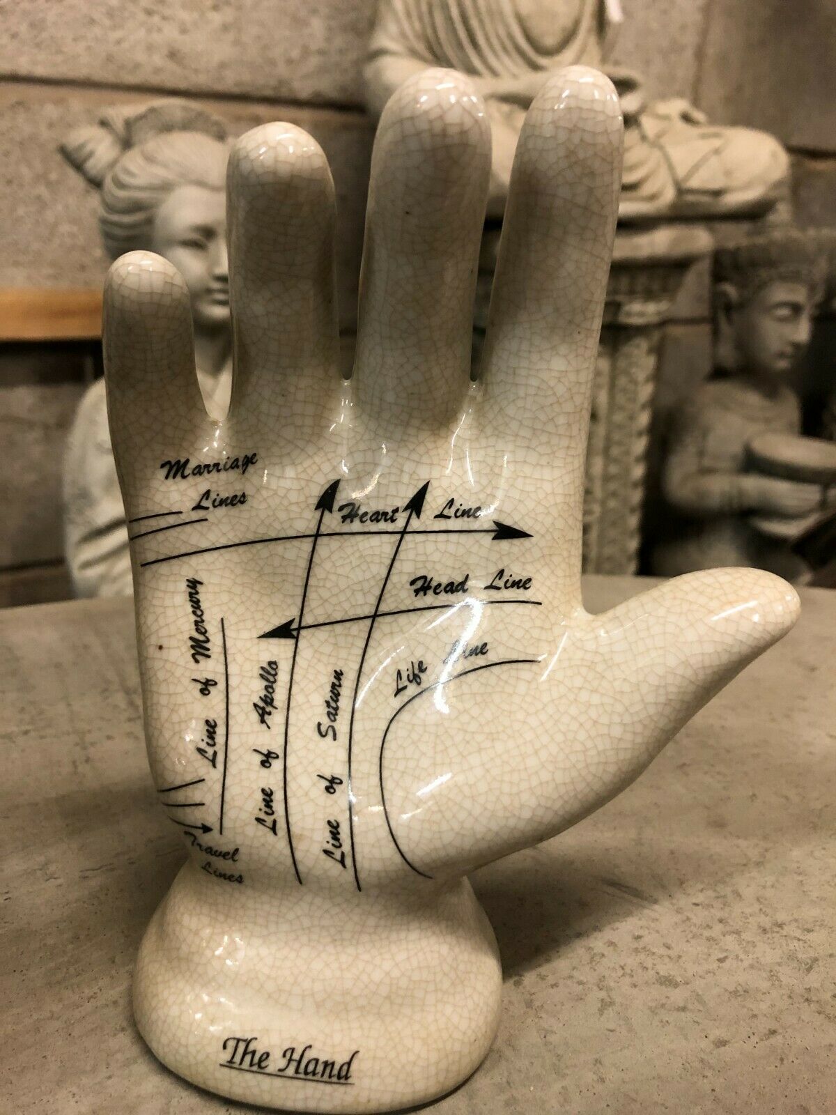 Close-up of ceramic palmistry hand ornament labeled with life, heart, and head lines. A unique decor piece for home or study.