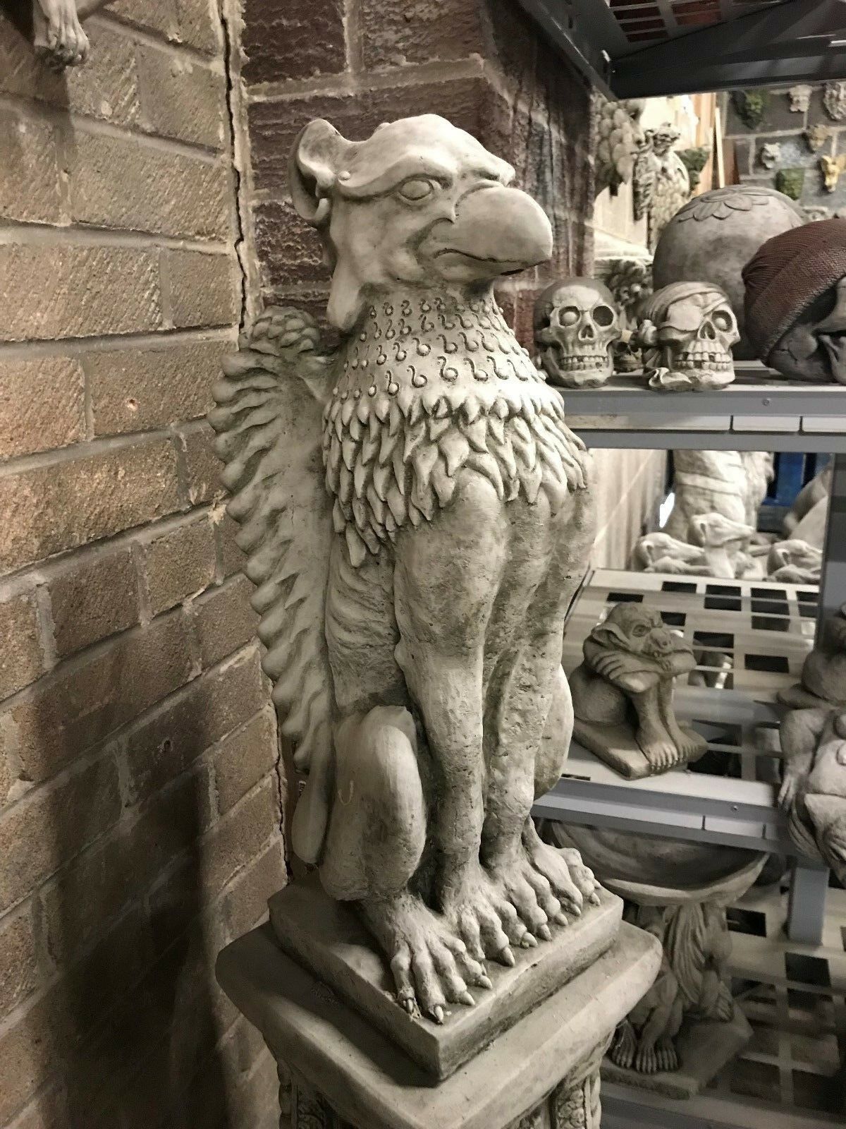 Side view of a Phoenix Garden Statue with intricate wing and feather detailing. Handmade stone sculpture for outdoor mythical decor.