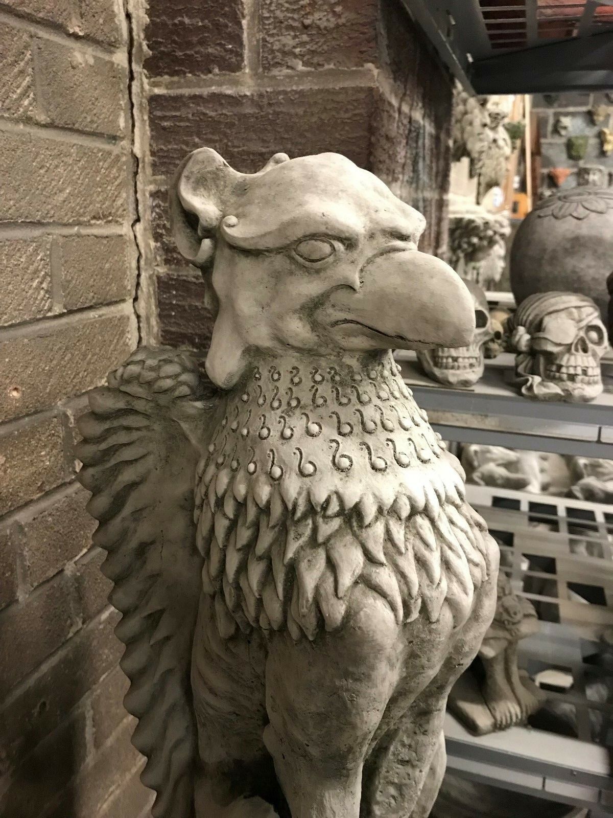 Close-up of Phoenix statue's head with fierce gaze and curled feathers. Ideal for themed garden decor or fantasy-inspired landscapes.