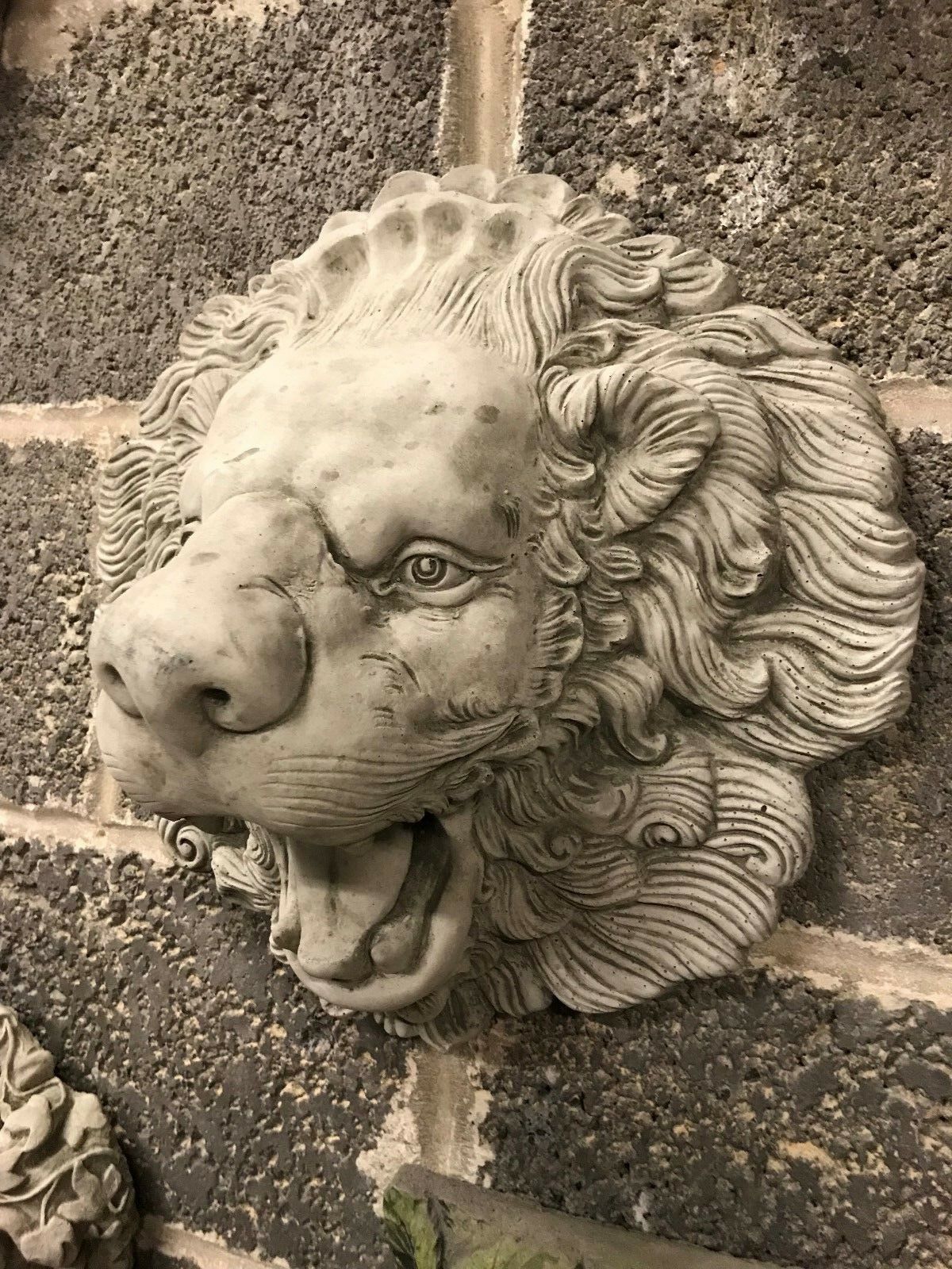 Angled view of antique lion water spout with realistic facial features and flowing mane. Durable limestone for outdoor garden decor.
