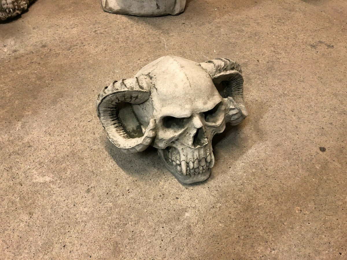 Angled view of Outdoor Skull Decor with horned skull design, crafted from solid stone for lawn or flower bed decoration.