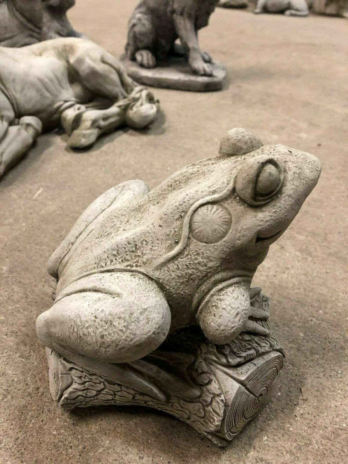 Side view of antique-style stone frog on log, a charming animal ornament for garden paths, lawns, or decorative outdoor spaces.