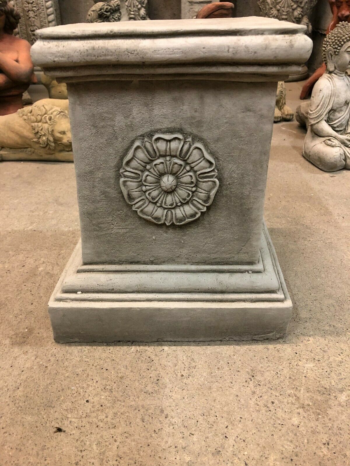 Close-up of Square Stone Plinth with detailed Yorkshire Rose carving, crafted from solid limestone for durable garden ornament use.