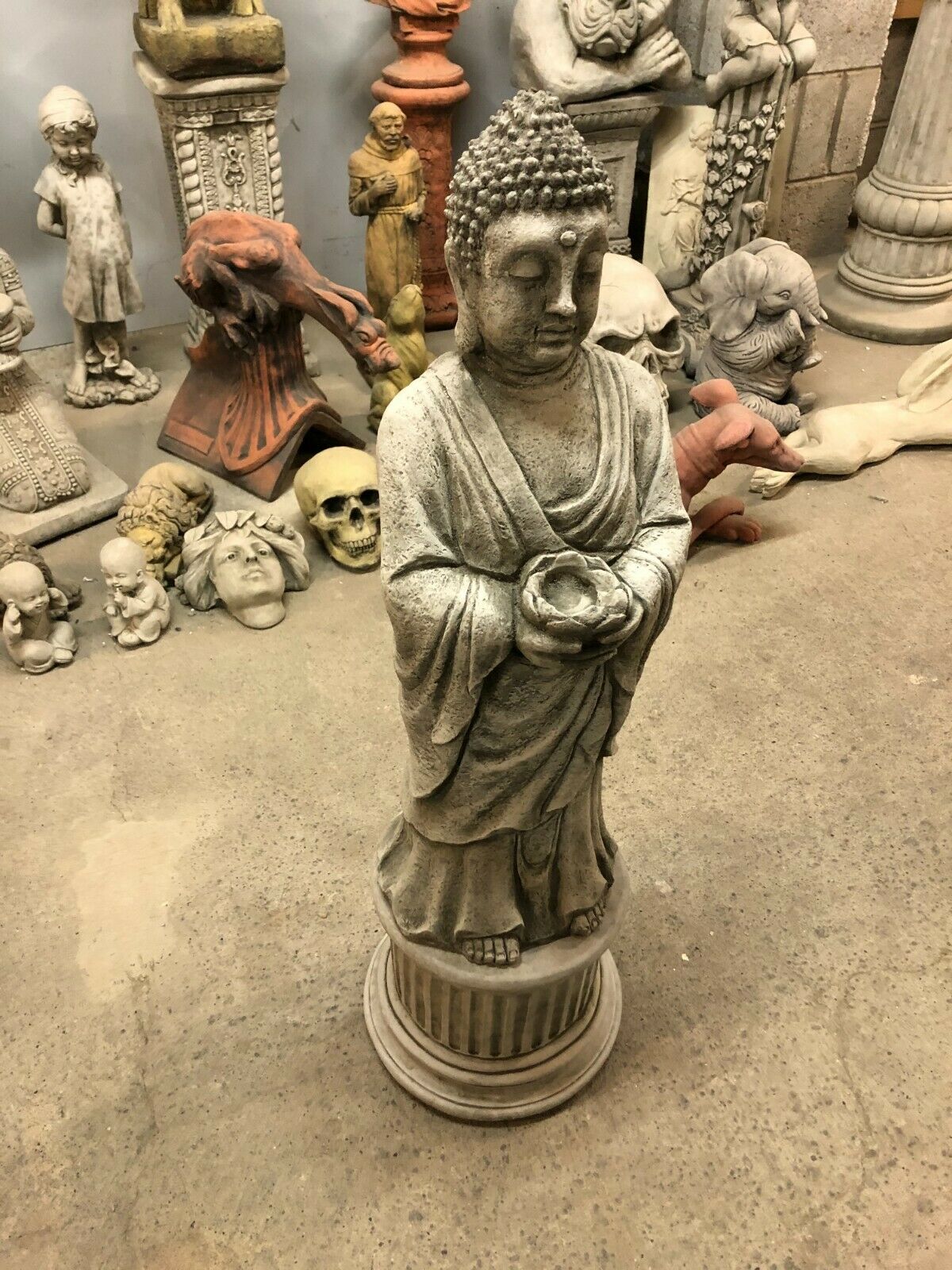 Side view of stone Buddha garden statue holding a tealight bowl, featuring detailed robe texture and serene expression.