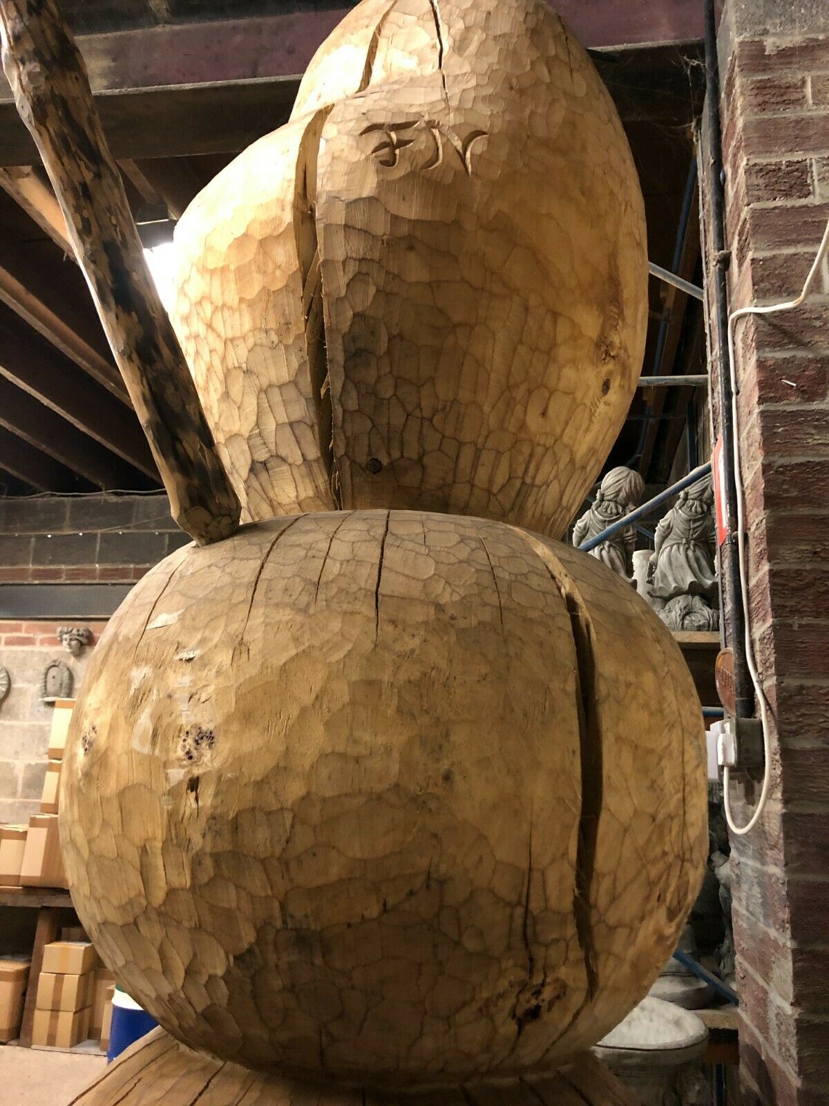 Back view of the Handcrafted Olaf Wooden Statue revealing natural wood cracks and carving marks for a rustic finish.