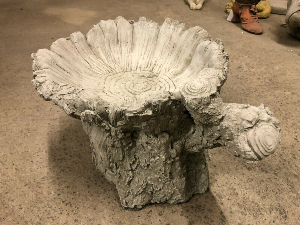 Tree stump bird bath with stone design featuring detailed bark texture and wide basin, ideal for garden decor and outdoor bird feeding.