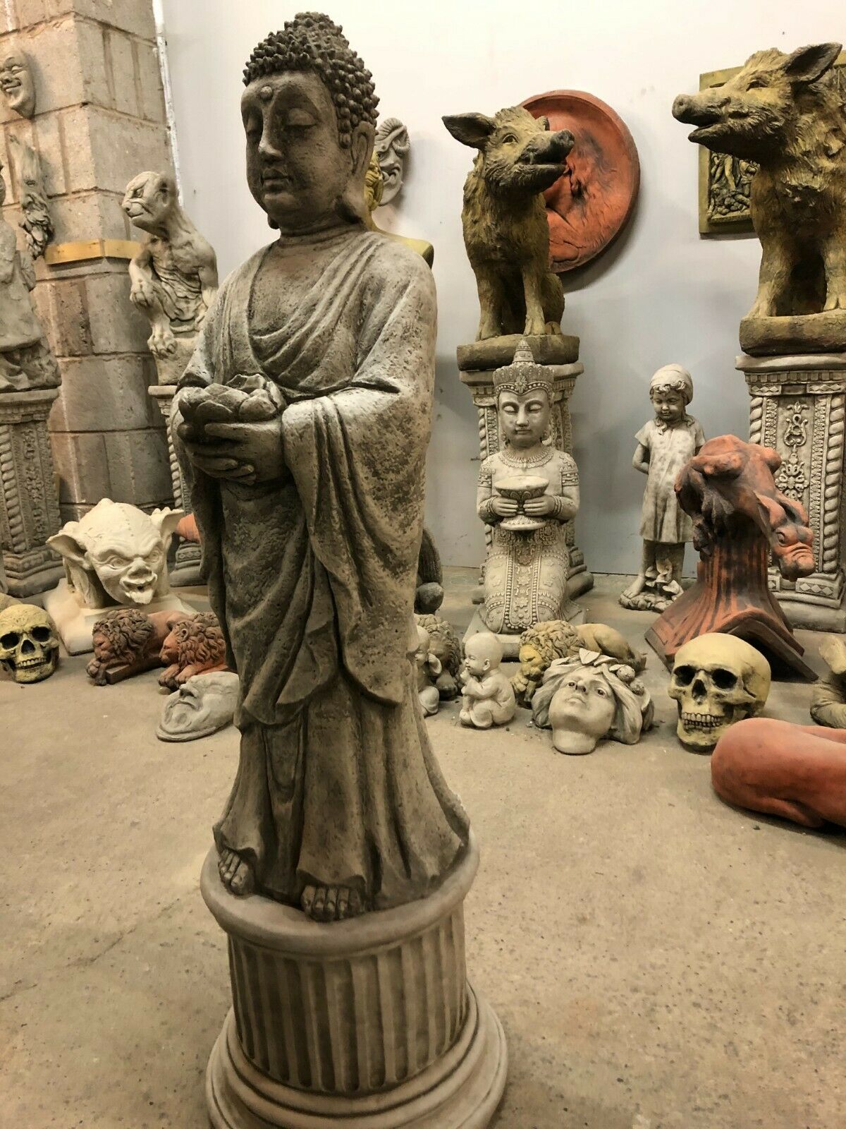 Angled view of tall stone Buddha sculpture with weathered finish, perfect for outdoor zen garden ambiance.