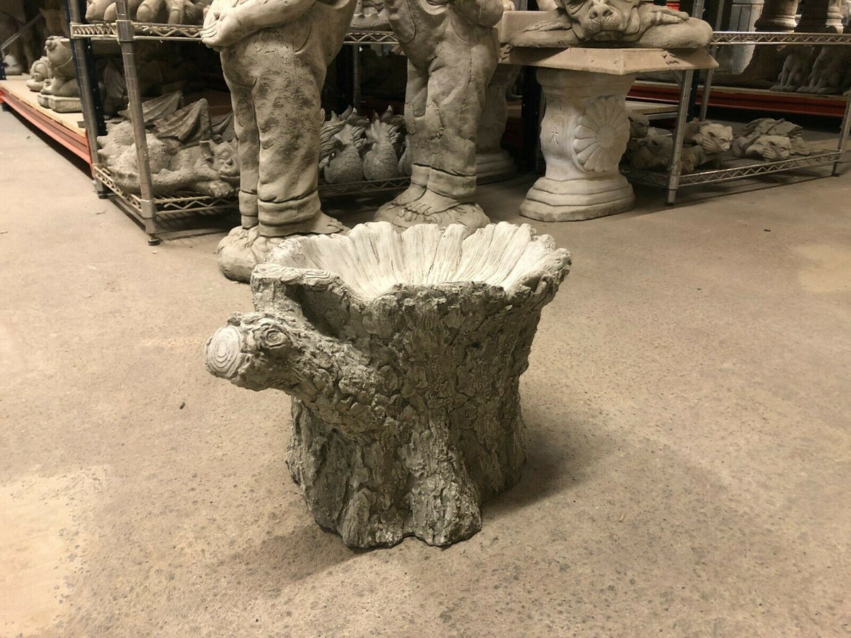 Heavy stone garden bird bath shaped like a tree stump, perfect for rustic outdoor spaces and wildlife-friendly garden decoration.