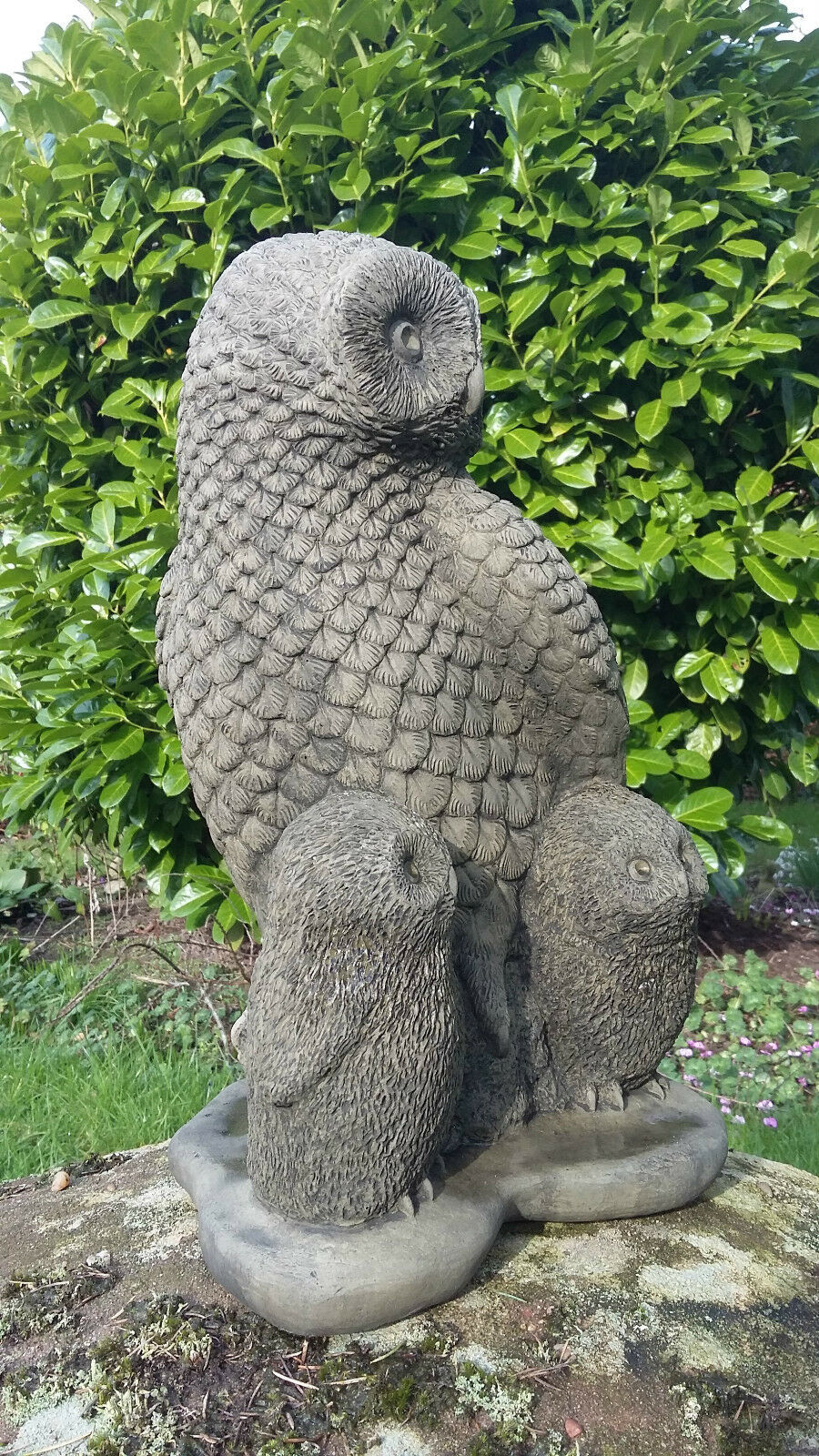 Angled view of the Stone Owl Garden Statue with two owlets, showcasing realistic craftsmanship and ideal for patios, lawns, or flower beds.