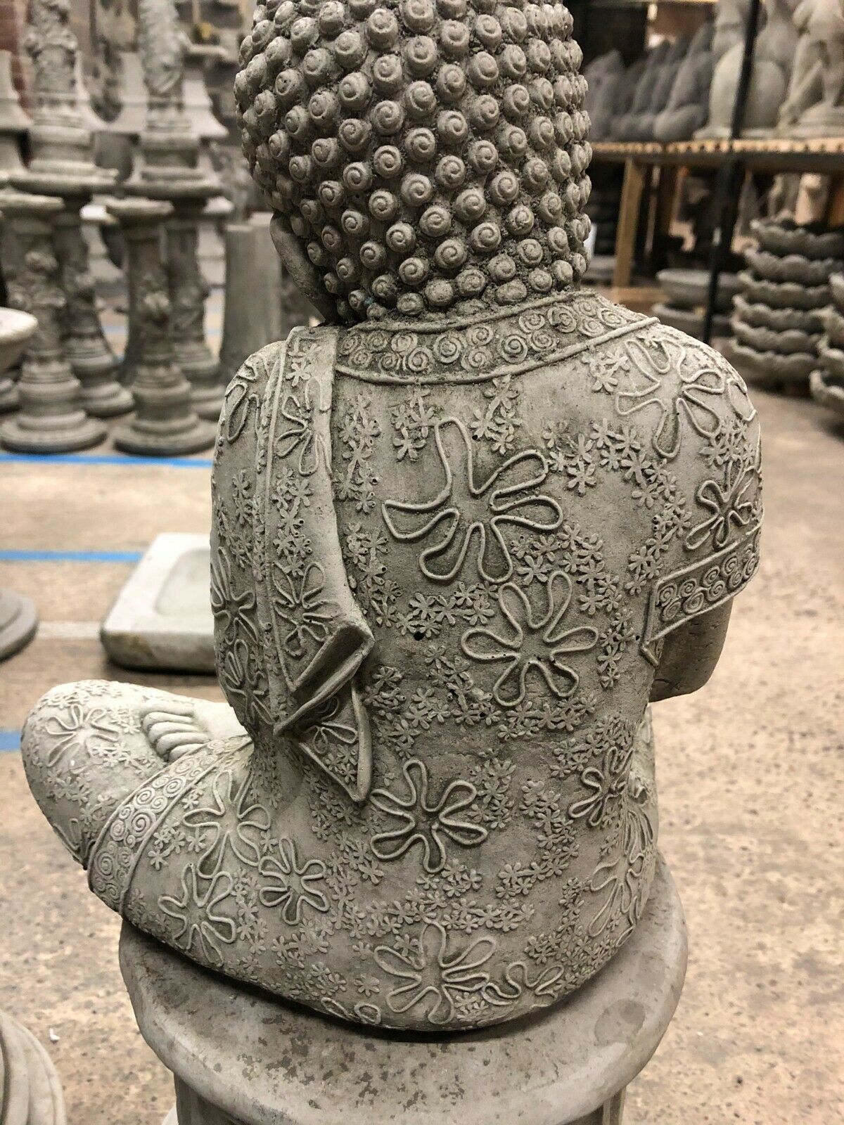 Back view of Stone Buddha Garden Ornament showing detailed floral patterns on robe. Made from frost-resistant limestone for lasting outdoor use.