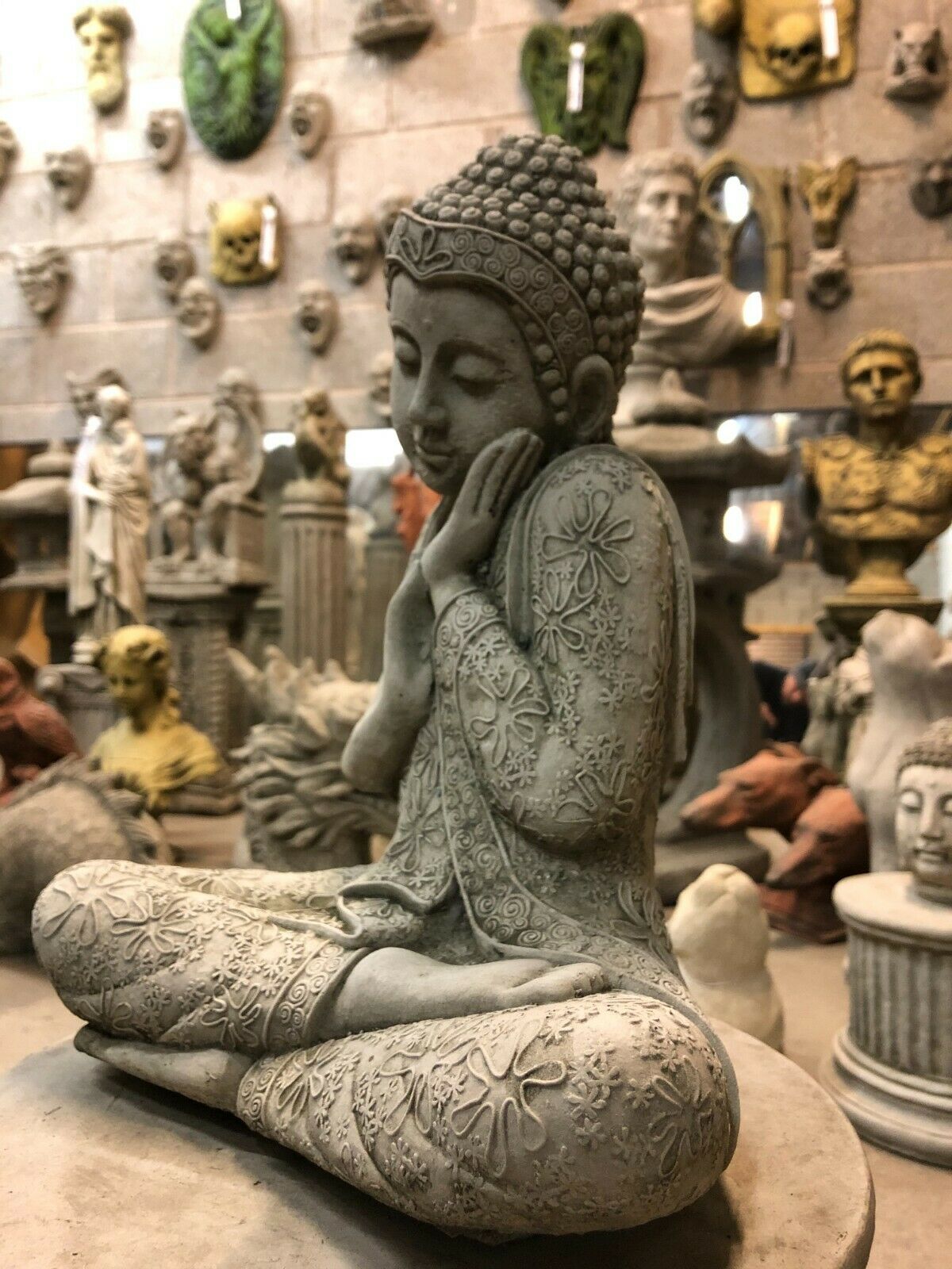 Side angle of Hands on Cheek Stone Buddha Garden Ornament, showcasing serene expression and ornate detailing. Enhances tranquil garden aesthetics.