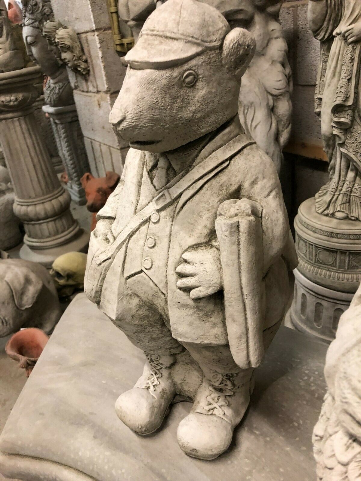 Close-up of poacher statue from Stone Gamekeeper & Poacher Statues-Garden Decor | Solid & Durable. Features detailed clothing and scroll, made from solid stone.