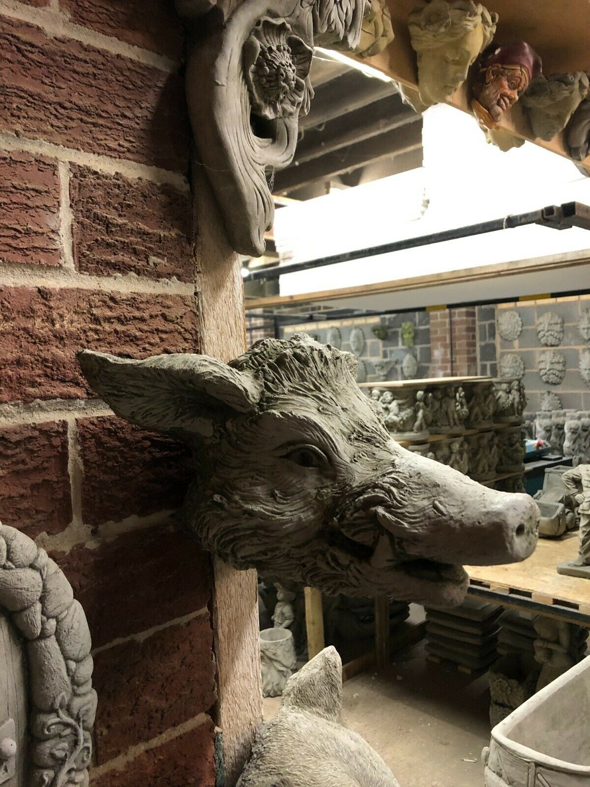 Side view of detailed Wild Boar Wall Plaque in stone, showcasing lifelike texture. Perfect rustic garden ornament for outdoor decor.
