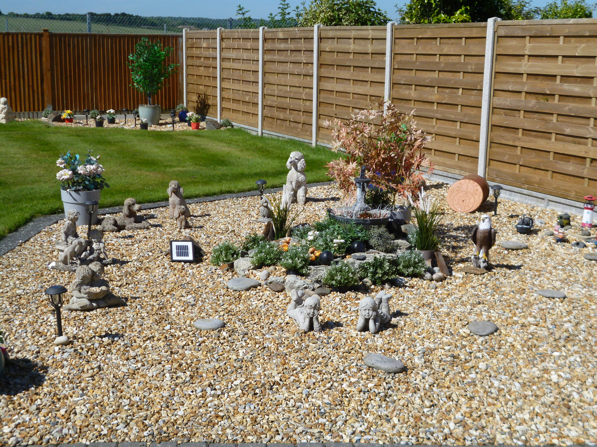 Decorative garden with multiple stone ornaments including boy and girl laying pair near central fountain. Ideal for elegant outdoor landscaping.