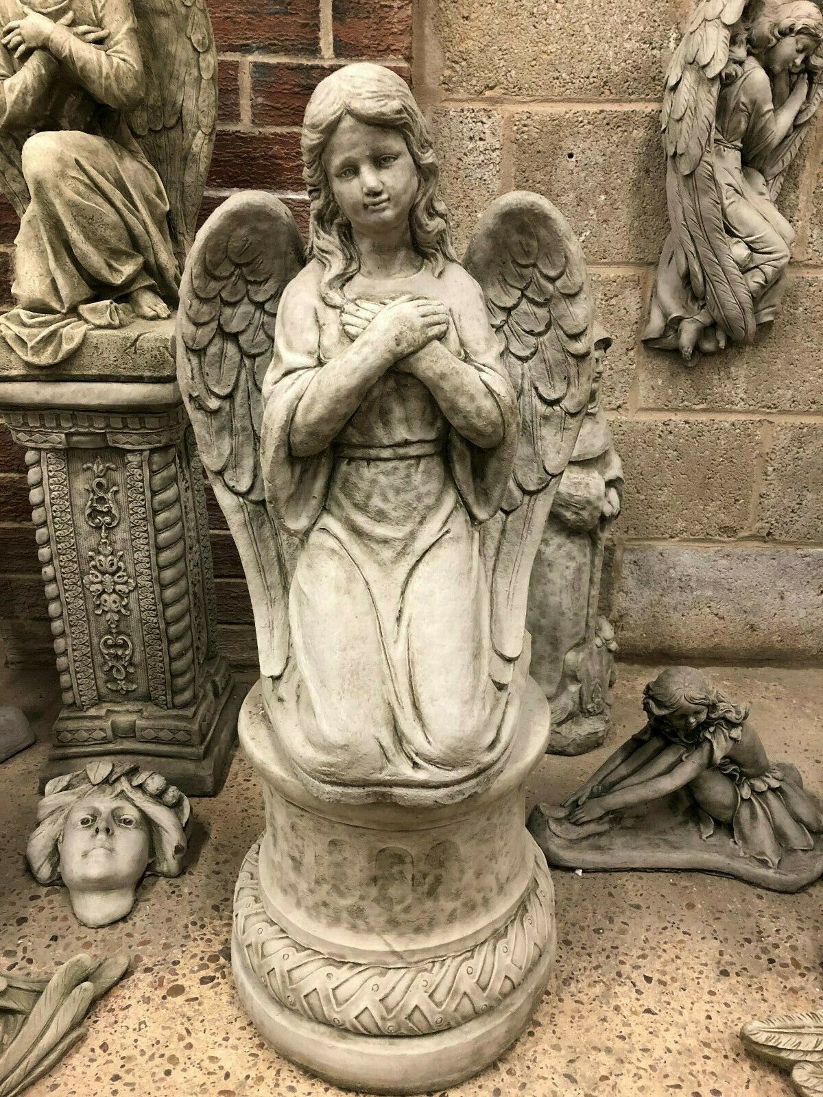 Antique limestone angel statue kneeling on a pedestal with folded hands, ideal for garden decor or memorial settings in home and garden spaces.