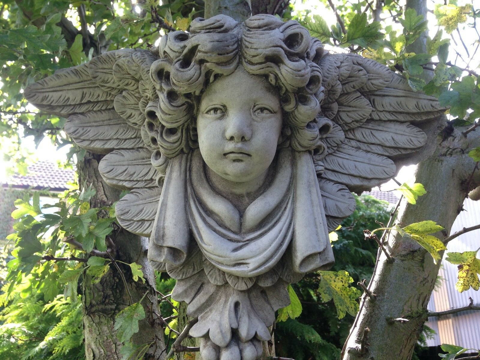 Close-up of Stone Cherub Garden Wall Shelf with intricate facial details and textured wings. Durable limestone ornament for home and garden wall decor.