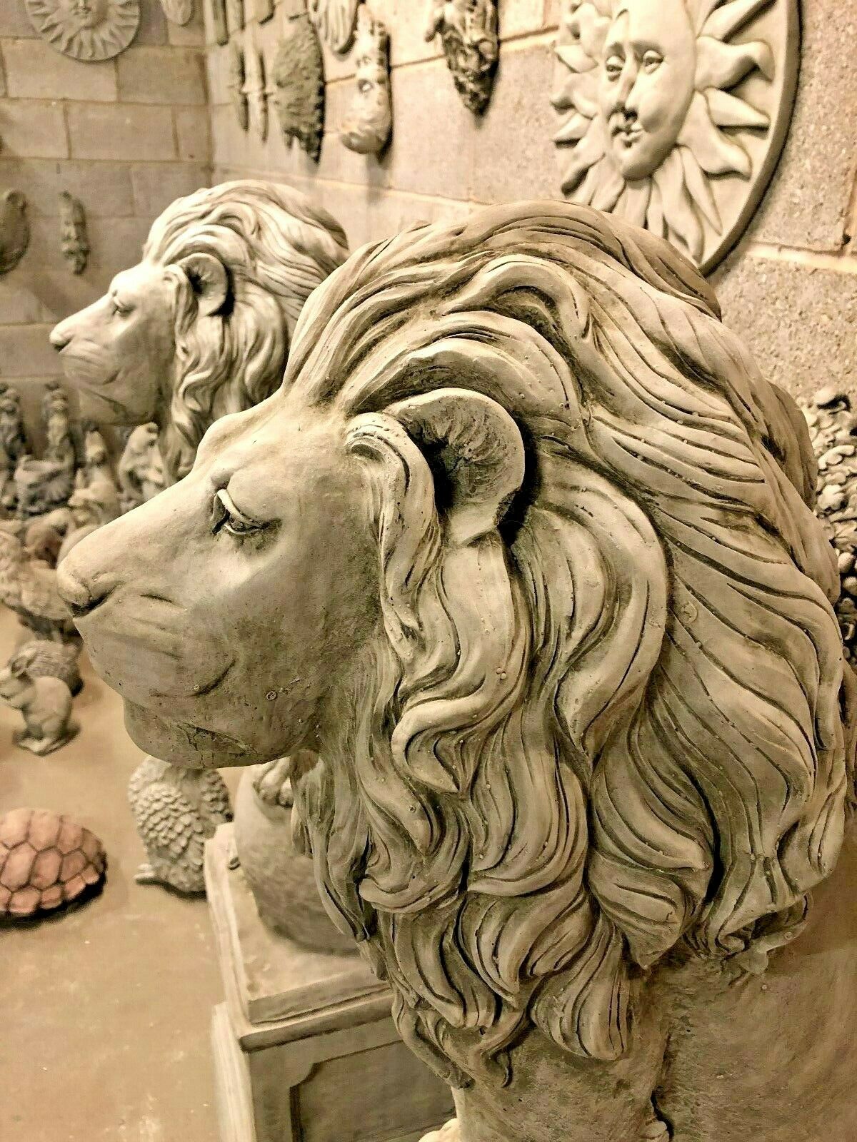 Side profile of lion garden statues with flowing manes, crafted from heavy stone for elegant and lasting outdoor decor.