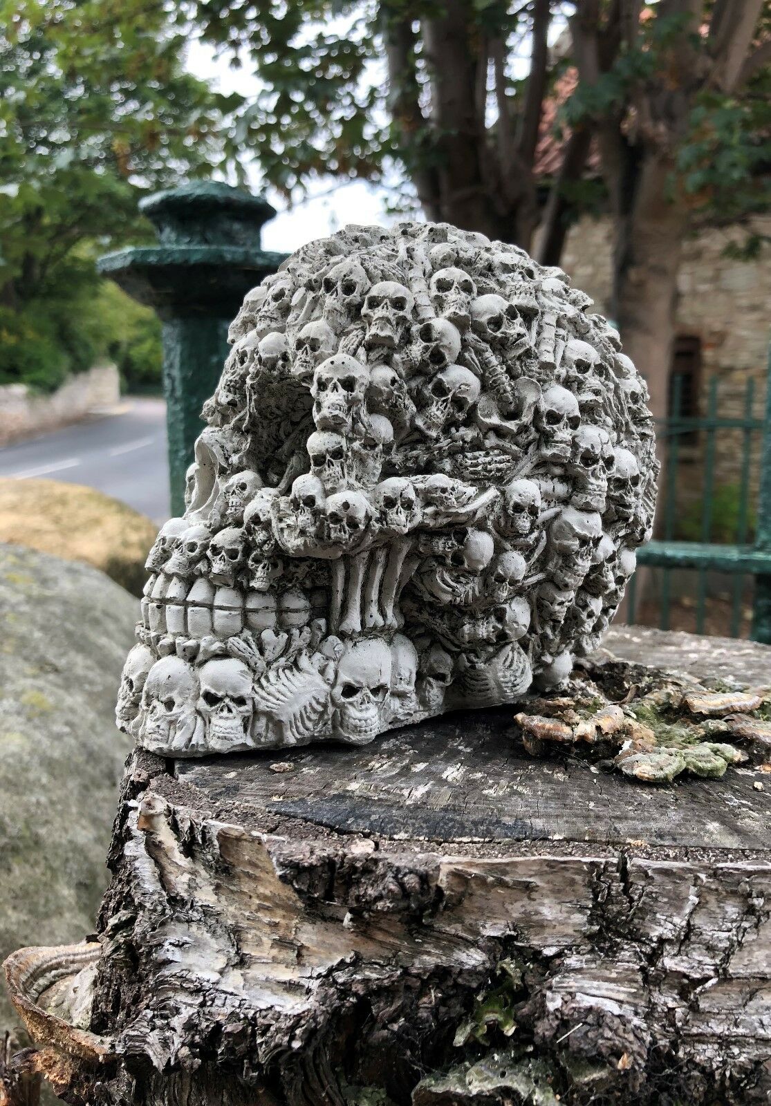 Profile view of Stone Skull Garden Ornament with layered skull design. Handmade gothic garden statue for outdoor or patio décor.