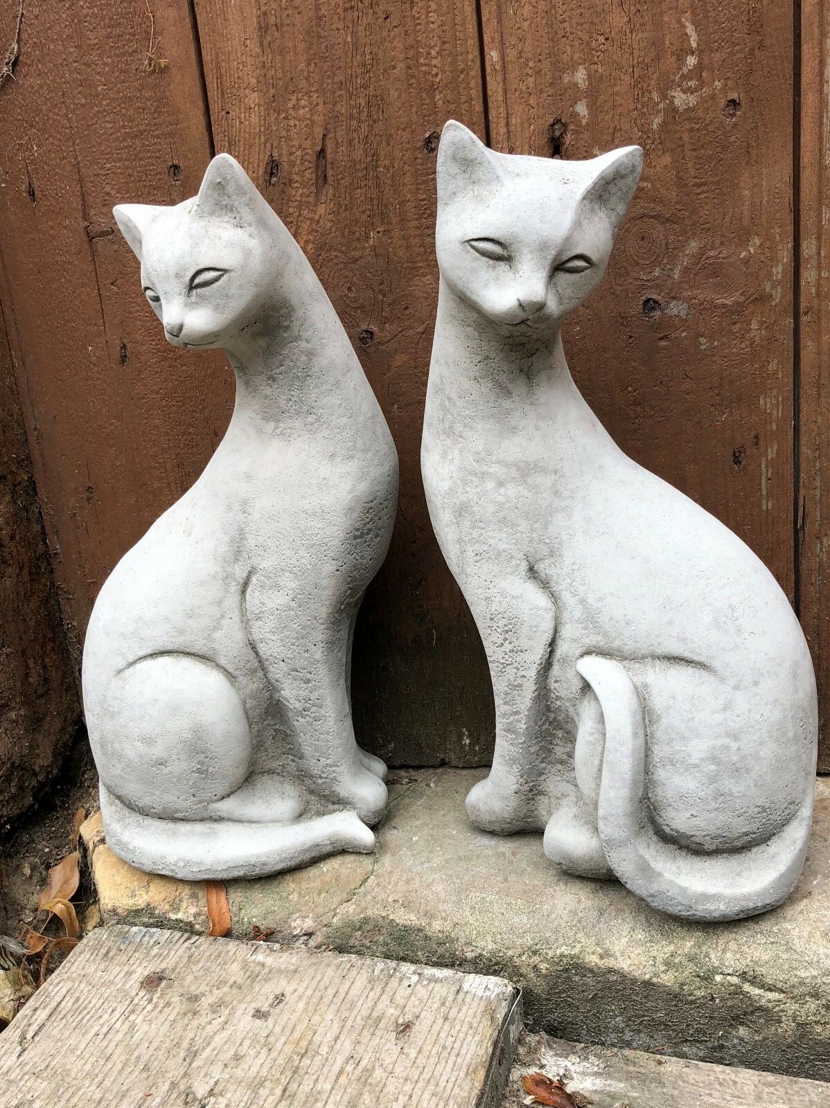Pair of weatherproof stone Siamese cat statues with graceful posture, enhancing garden aesthetics with timeless charm.