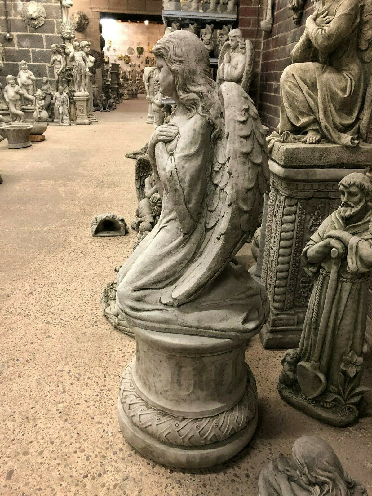 Side view of antique angel pedestal statue with intricate wing and robe detailing, designed for garden sculpture collections.