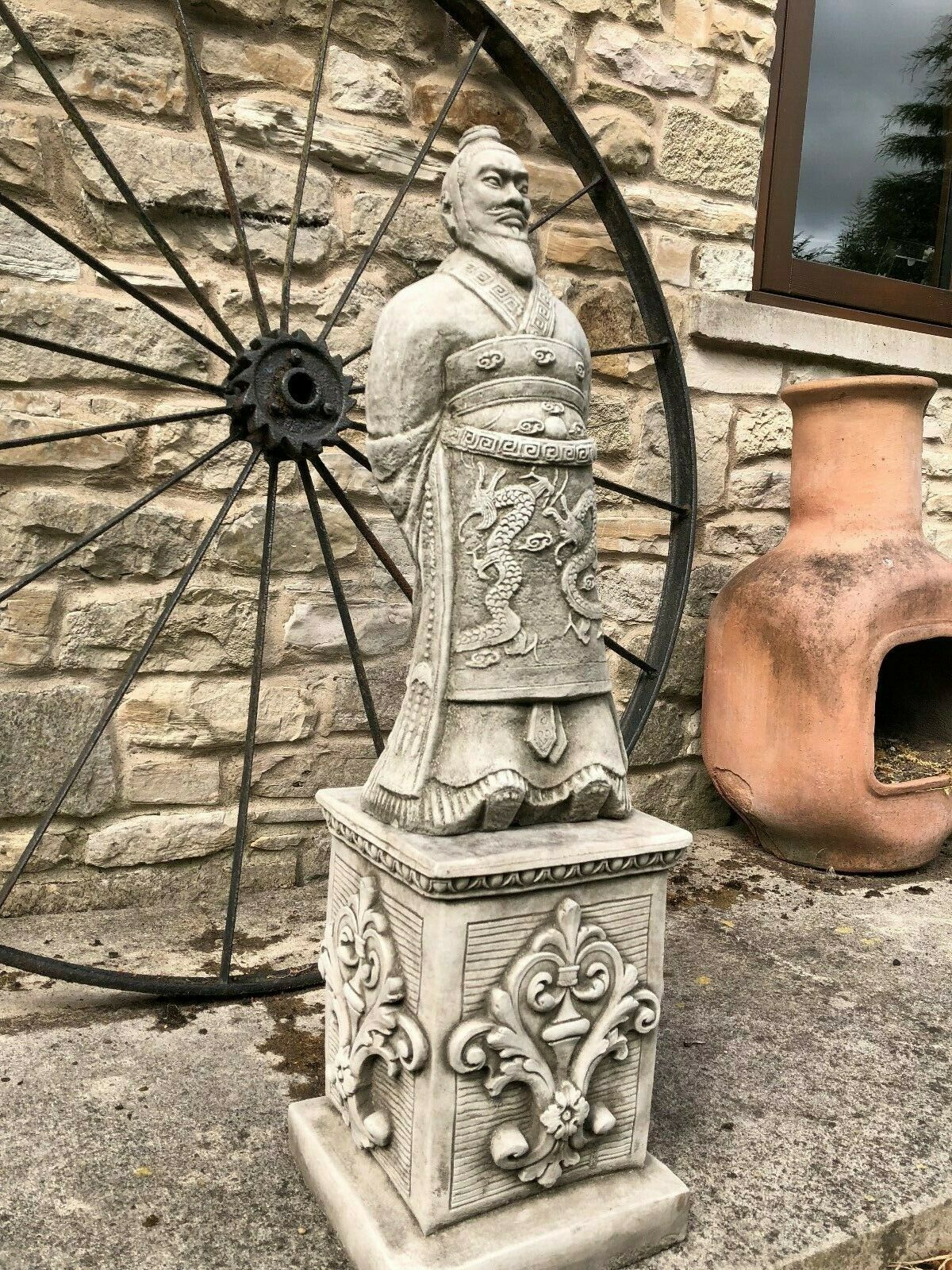 Angled view of the Stunning Stone Zhan Shi Warrior Garden Plinth Statue highlighting its intricate dragon carvings and decorative plinth base.