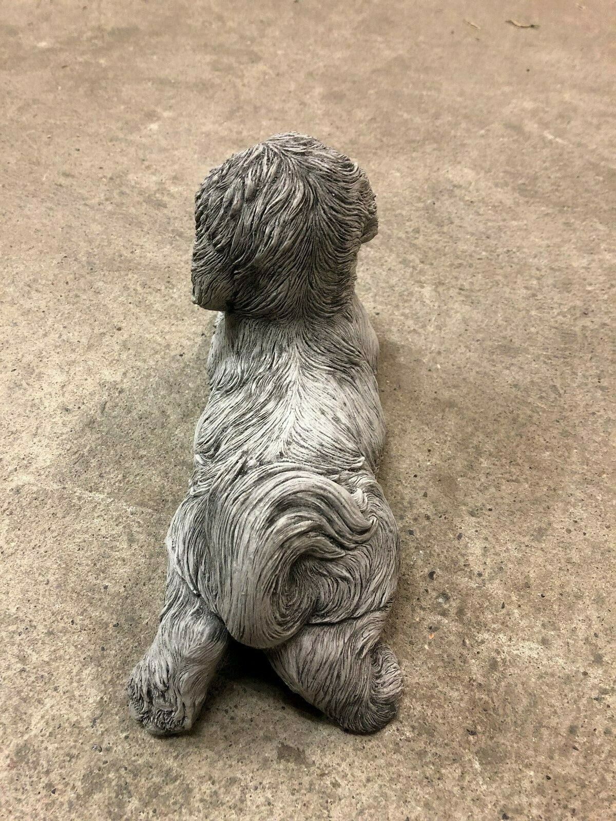 Rear view of Shih Tzu Stone Garden Ornament highlighting curled tail and lifelike design. A charming addition to outdoor garden sculpture collections.
