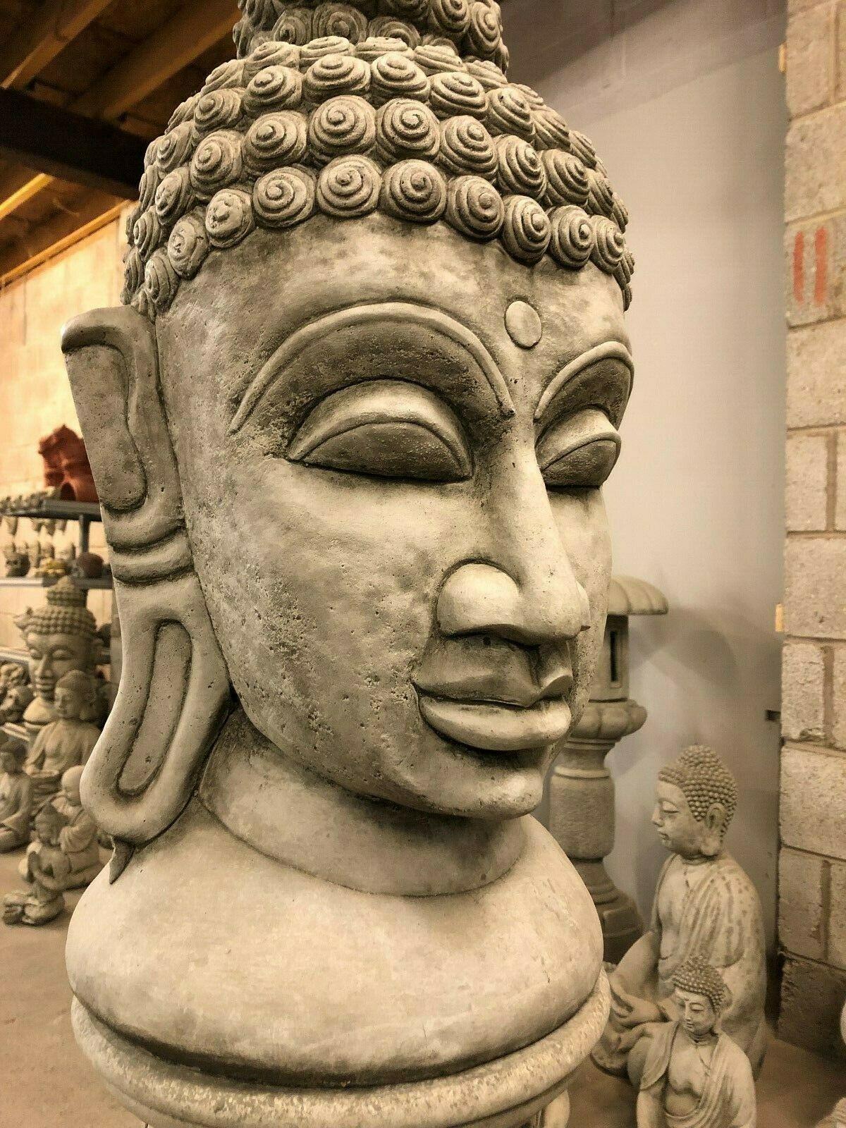 Side close-up of Buddha Head Garden Statue showing serene facial expression. Handcrafted stone sculpture for peaceful garden decor.