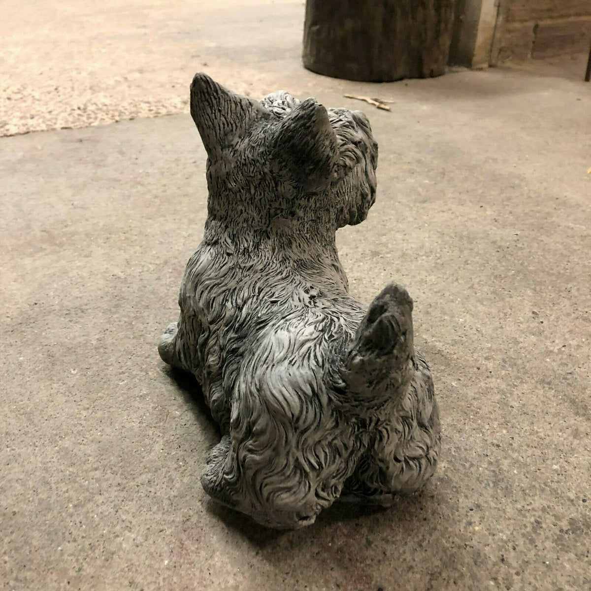 Angled rear view of Scottish Terrier stone ornament with curled tail and textured coat, ideal for garden or lawn display.