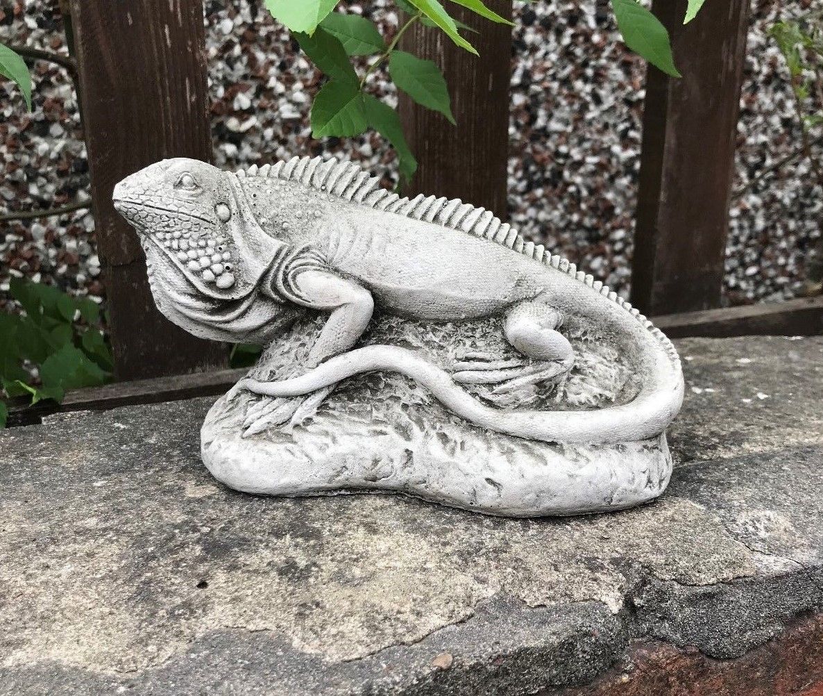 Limestone iguana ornament from the Garden Stone Collection on a patio ledge, designed for durable and decorative outdoor use.