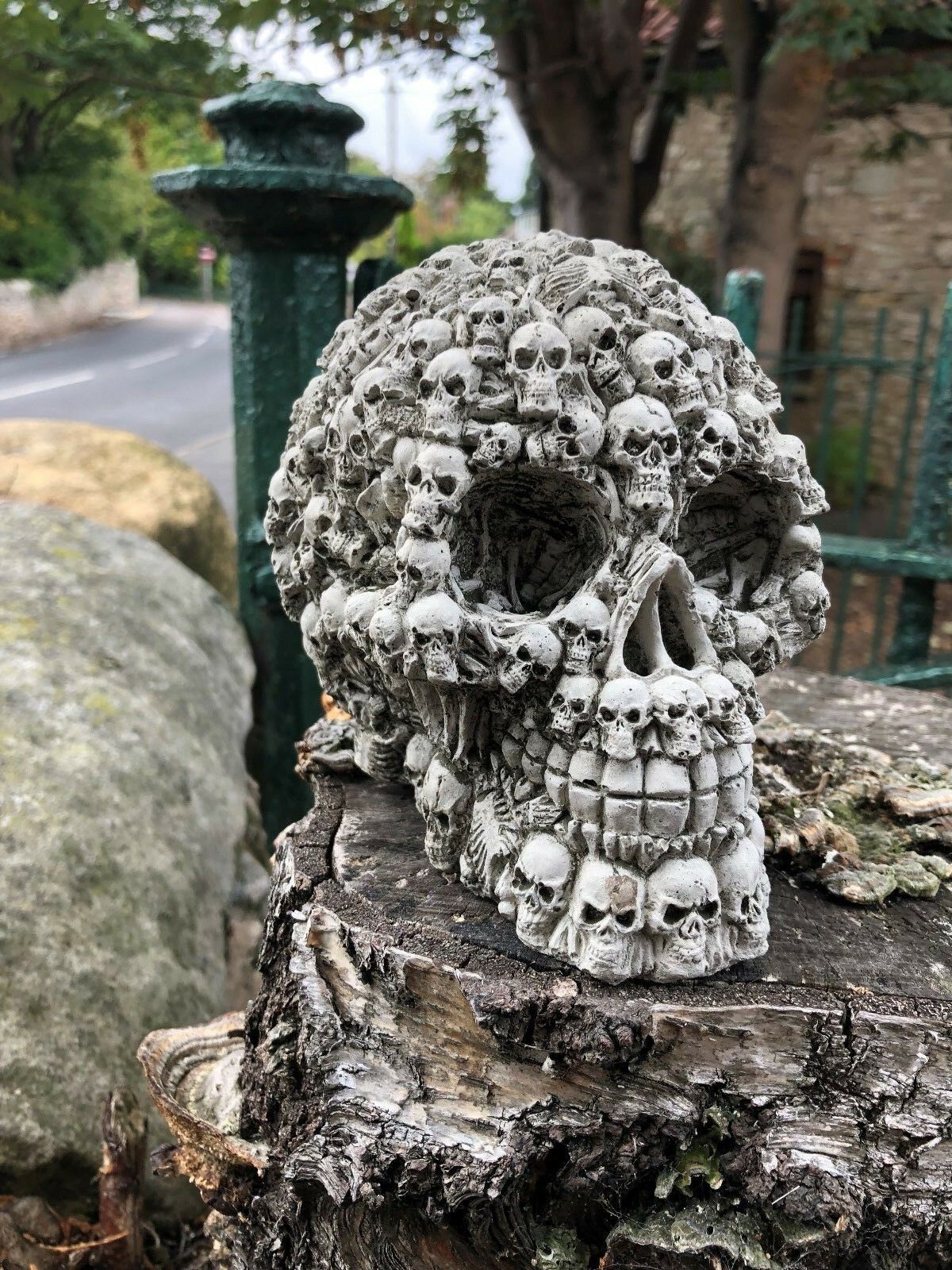Angled side view of Stone Skull Garden Ornament with textured skull surface. Unique limestone garden sculpture for outdoor decoration.