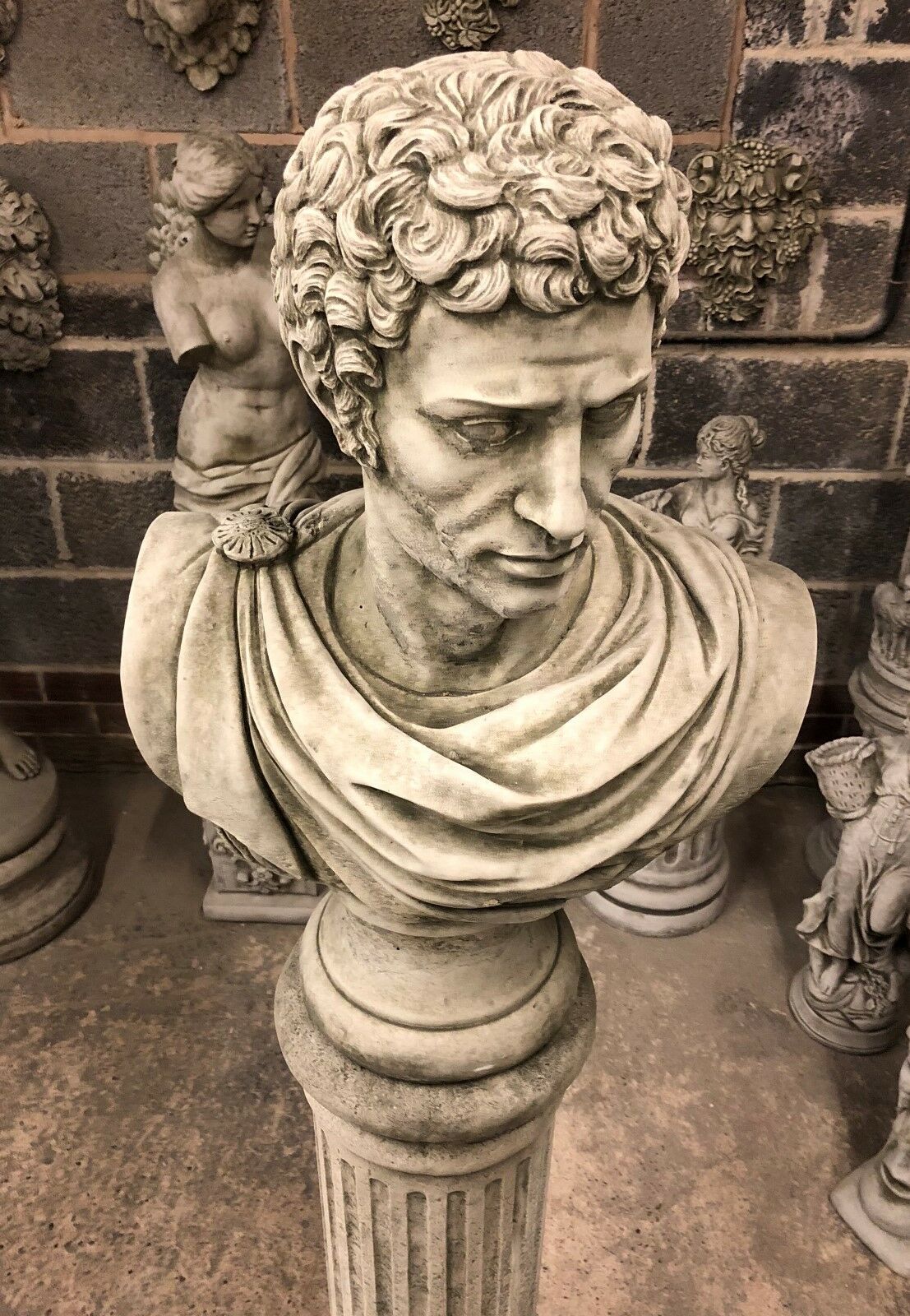 Top-down view of Stone Marc Anthony Bust Statue, showing intricate hair and toga detail on a Roman-style limestone column for garden decor.