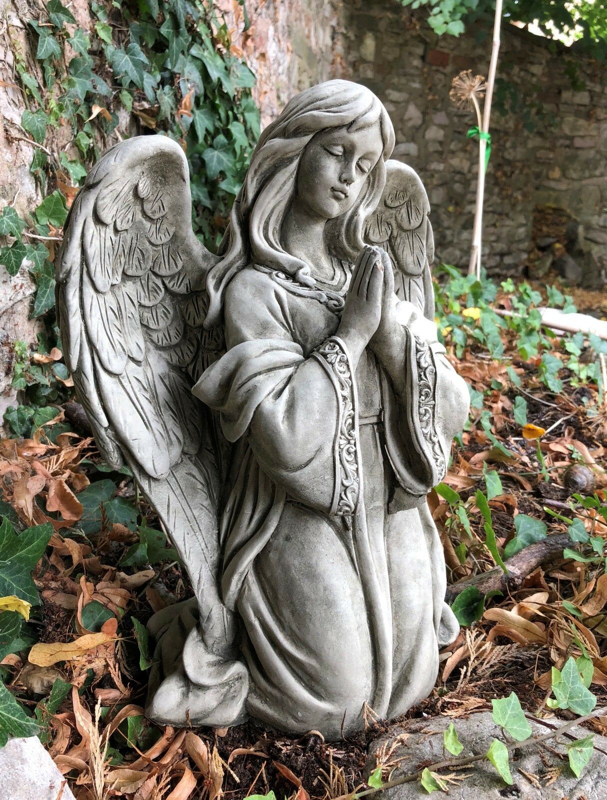 Side view of Stone Praying Angel Statue showing detailed wings and serene expression, crafted from solid limestone for garden use.