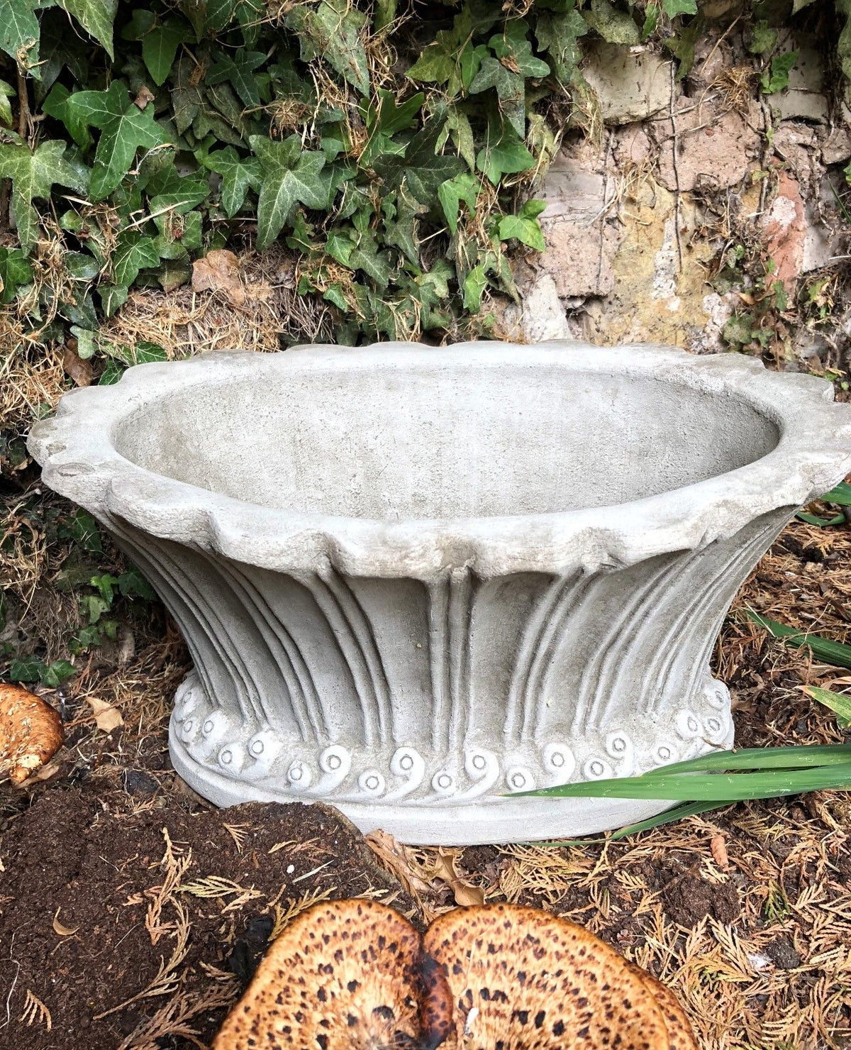 Close-up of fluted garden pot planter with ornate stone design, showcasing its solid build and decorative craftsmanship.