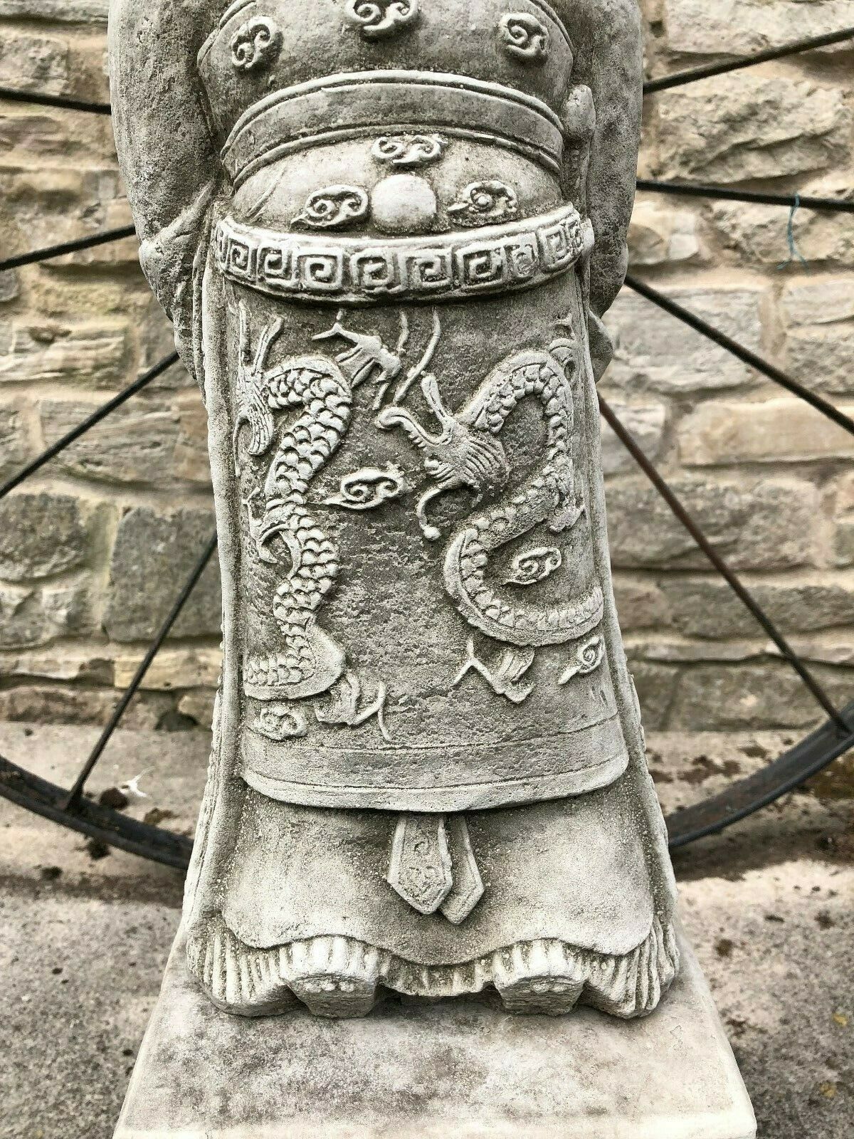 Close-up of the dragon carvings on the Zhan Shi Warrior's robe, illustrating the statue's Asian-inspired ornamental detailing.